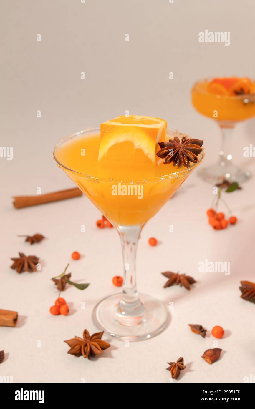 Orangensaft im hohen Glas mit Orangenwürfel und Gewürzen Stockfoto