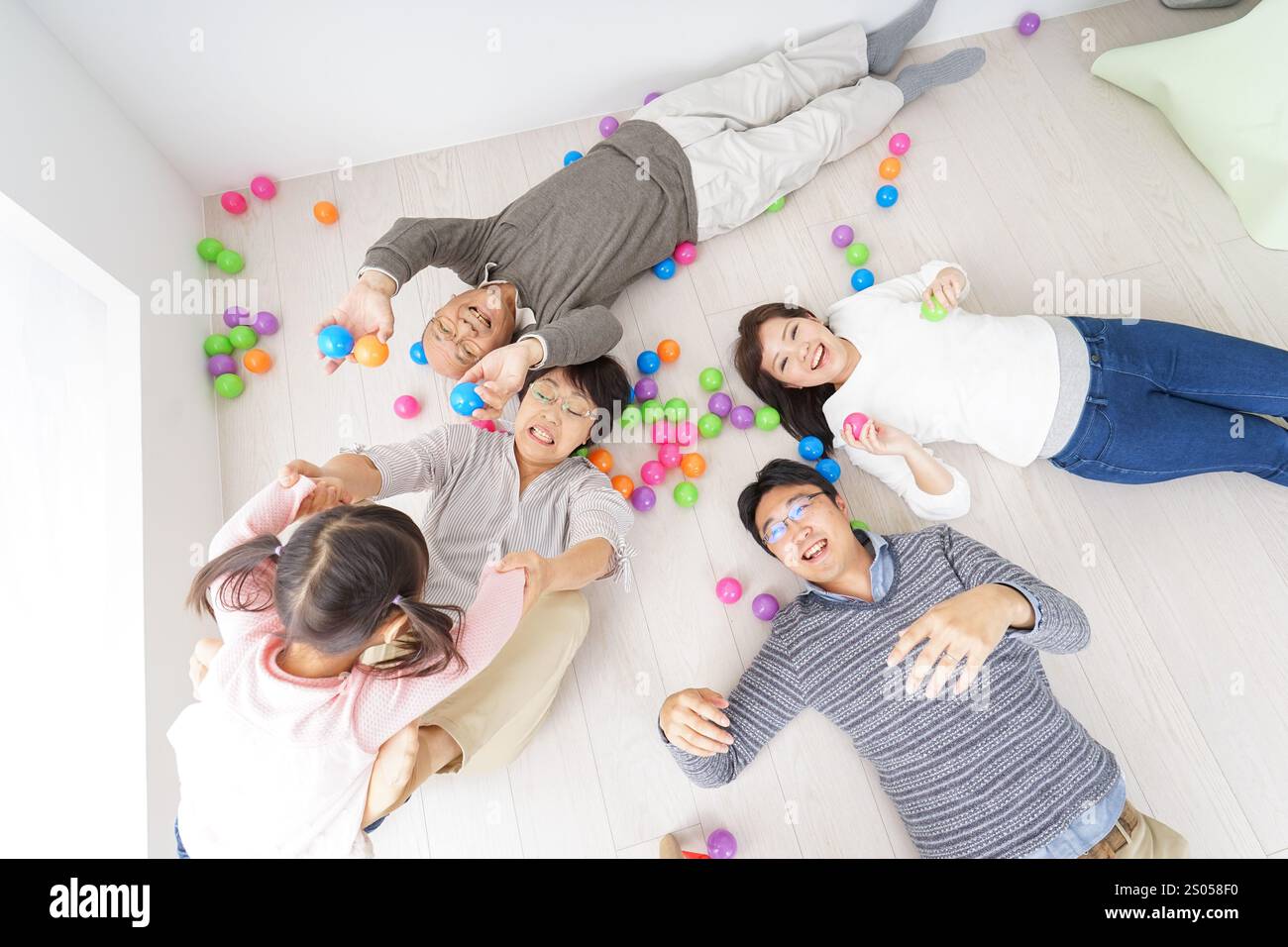 Familie von drei Generationen, die in einem Zimmer liegt Stockfoto