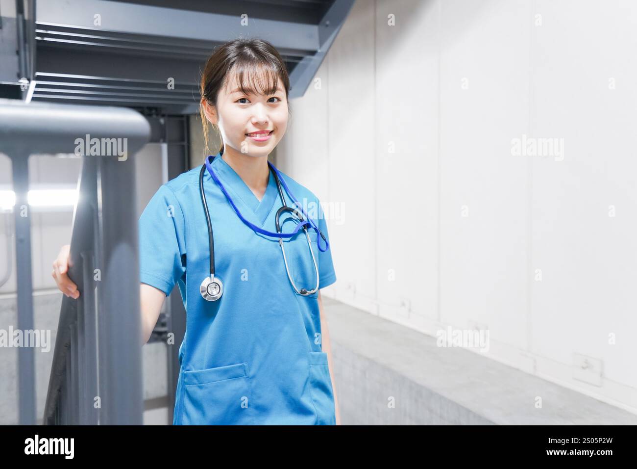 Junge Krankenschwester auf der Treppe Stockfoto