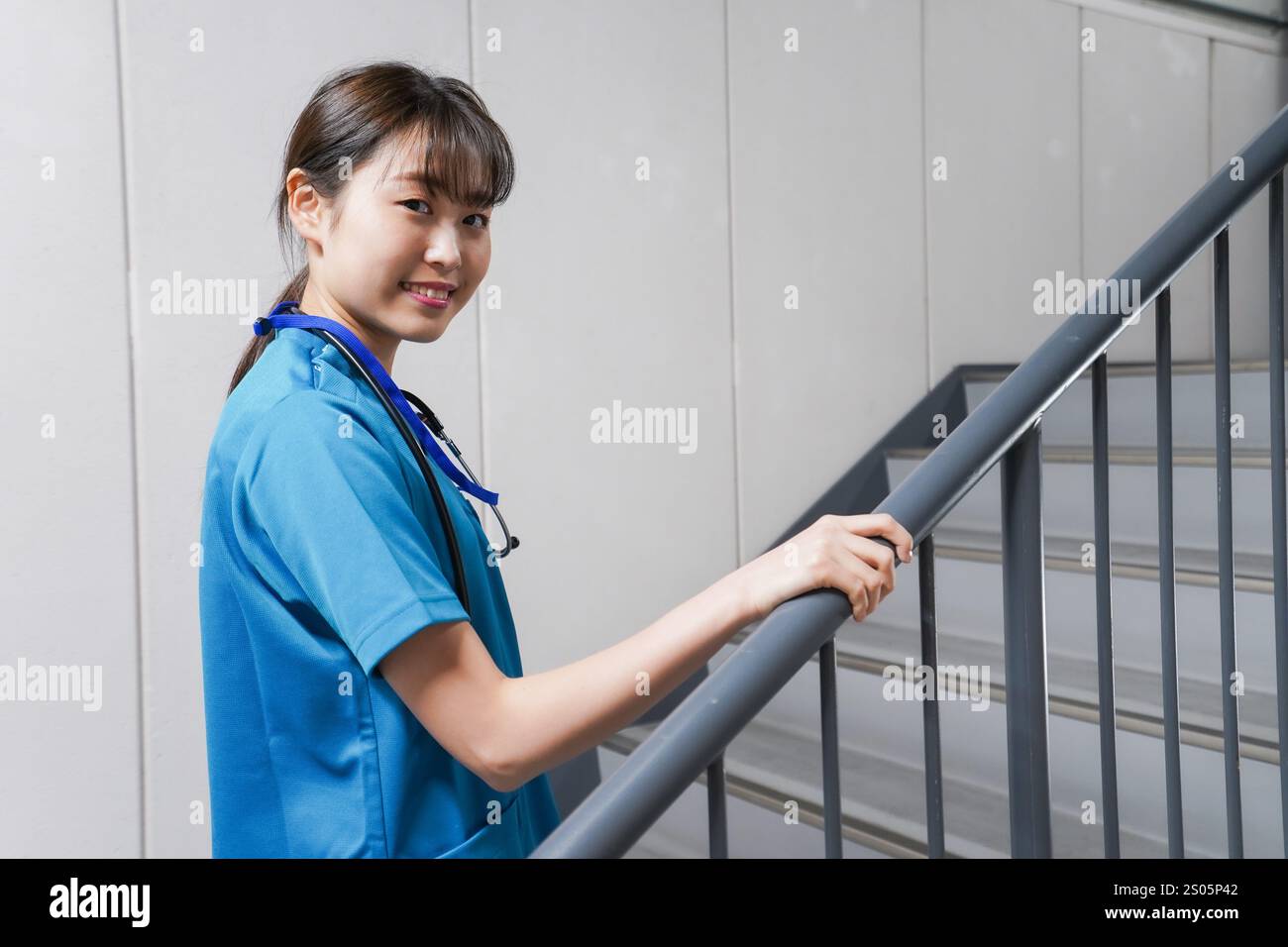 Junge Krankenschwester auf der Treppe Stockfoto