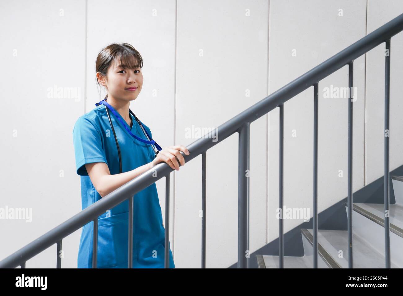 Junge Krankenschwester auf der Treppe Stockfoto