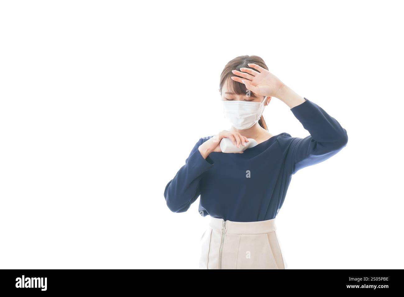 Eine junge Geschäftsfrau, die ihre Temperatur misst Stockfoto