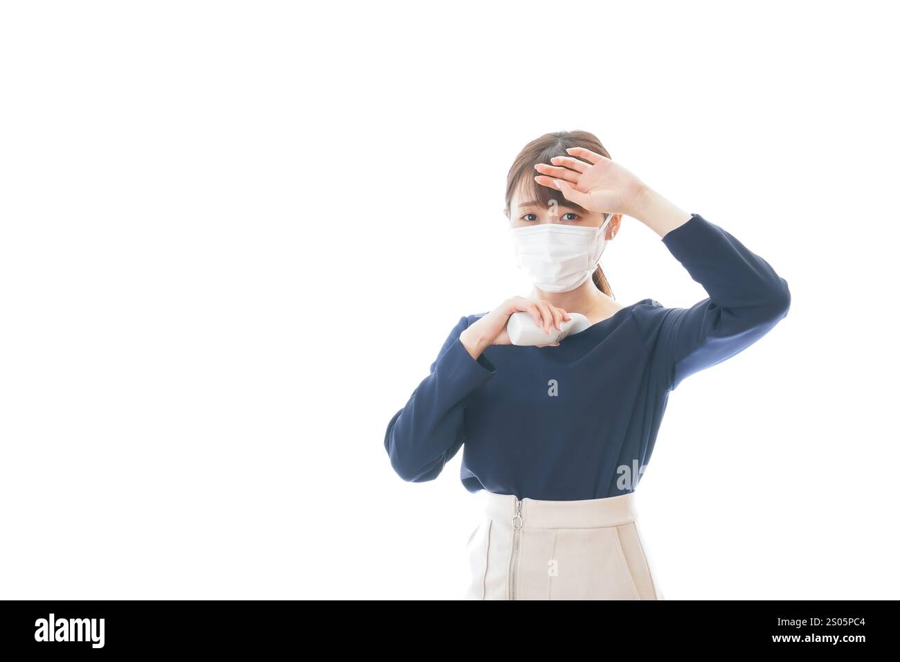 Eine junge Geschäftsfrau, die ihre Temperatur misst Stockfoto