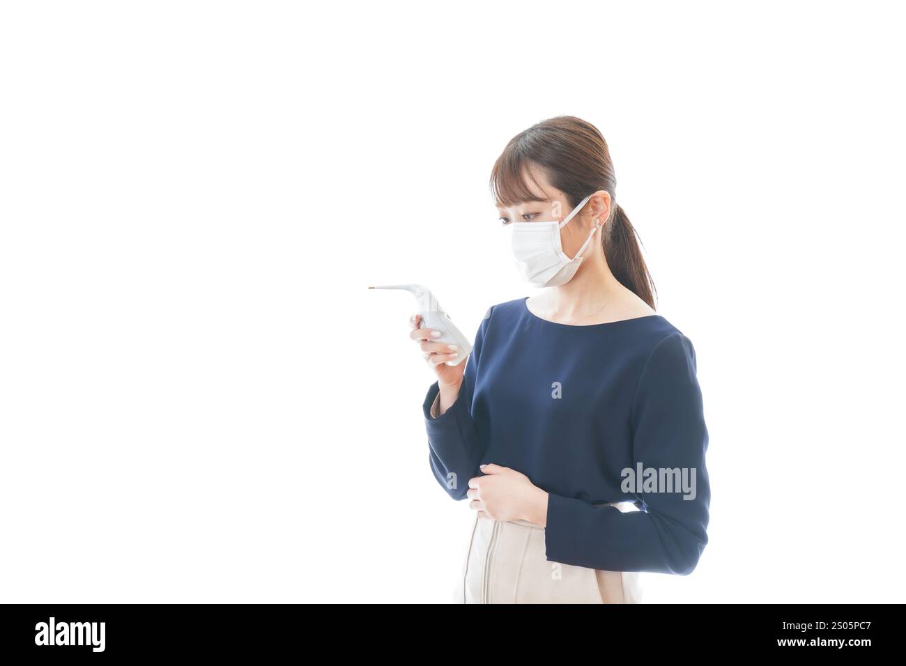 Eine junge Geschäftsfrau, die ihre Temperatur misst Stockfoto