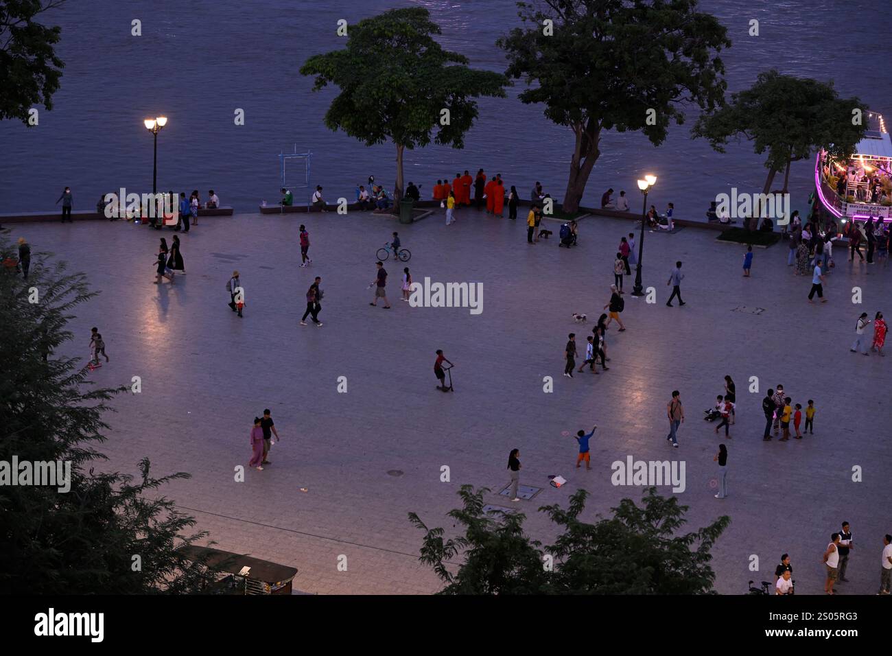 Einheimische und Touristen genießen einen gemütlichen Abendspaziergang am Sisowath Quay, am Fluss, Phnom Penh, Kambodscha. Stockfoto