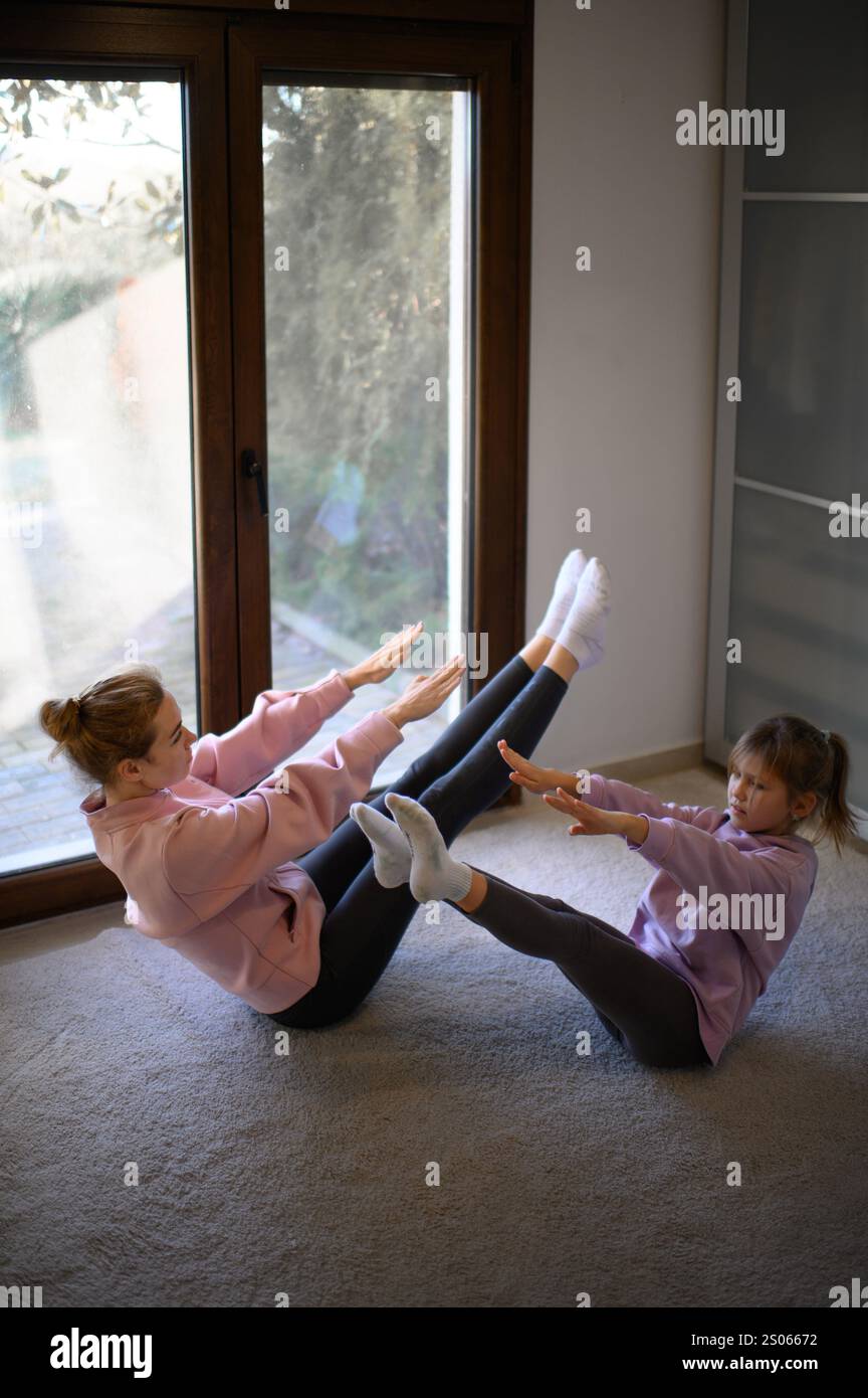 Mutter und Tochter machen zu Hause Pilates mit Online-Lehrer Stockfoto