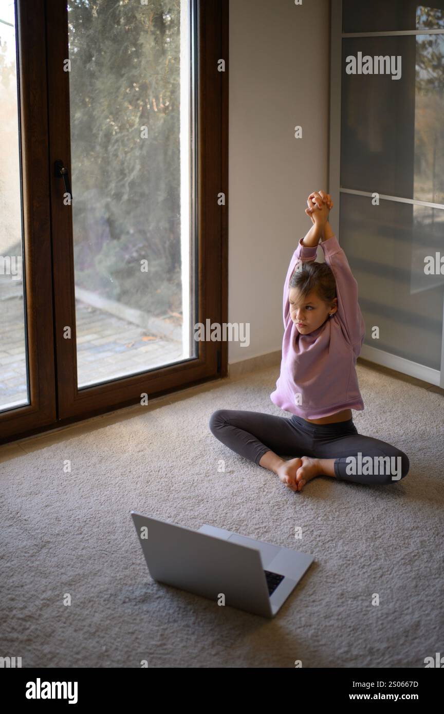 Mutter und Tochter machen zu Hause Pilates mit Online-Lehrer Stockfoto