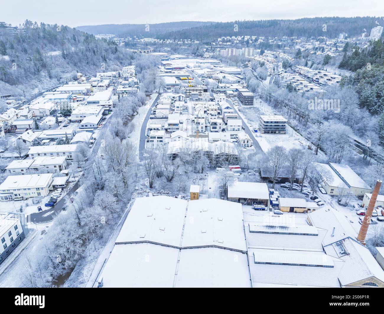 Schneebedeckte Fläche mit Fabrik- und Wohnsiedlung in hügeliger Landschaft, Nagold, Schwarzwald, Deutschland, Europa Stockfoto