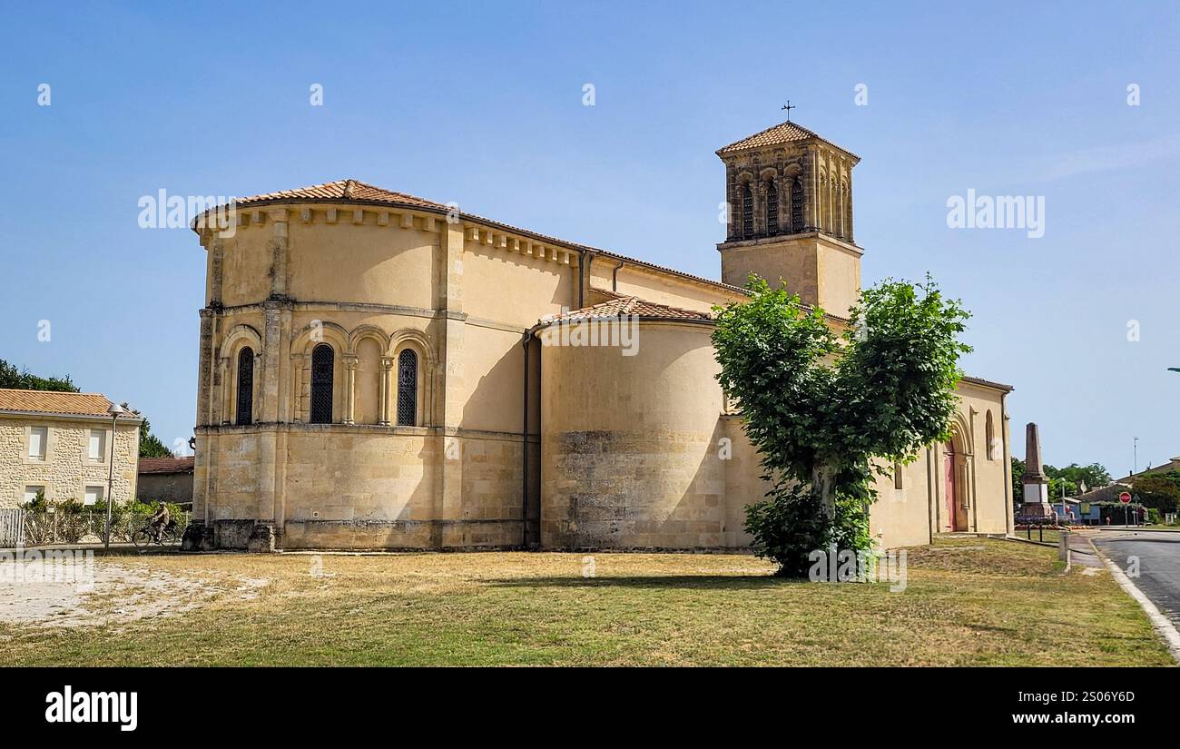 Römische Kirche Grayan, Medoc, Nouvelle-Aquitaine, Südwesten Frankreichs. Im Vordergrund - ein grüner Baum in Form eines Herzens. Stockfoto