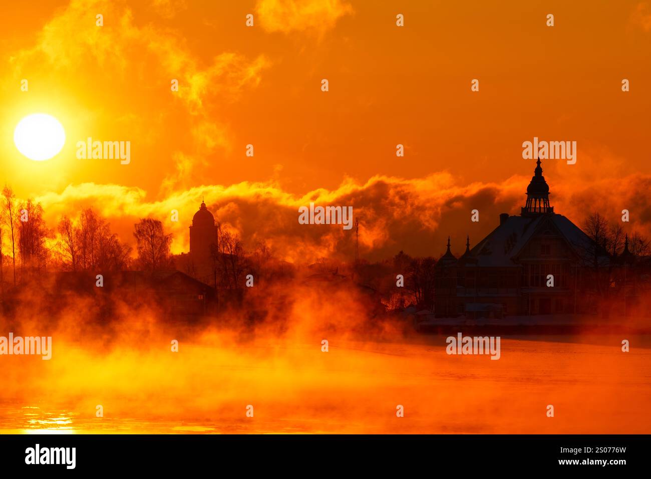 Helsinki, Finnland - 15. Januar 2021: Flammender Morgensonnenaufgang hinter historischem Holzhaus, jetzt Restaurant NJK auf der Insel Valkosaari in Helsinki Archi Stockfoto