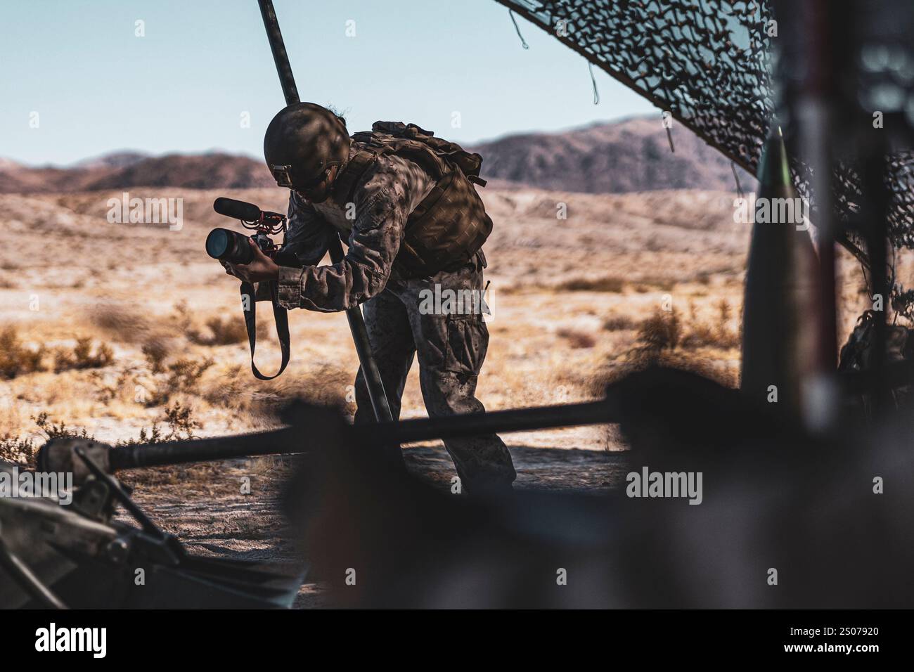US Marine Corps CPL. Iris Gantt, gebürtige Katy, Texas, Spezialist für Kampfgrafik mit Kommunikationsstrategie und Operationen, Hauptquartier-Bataillon, Marine Air-Ground Task Force Training Command, Marine Corps Air-Ground Combat Center, nimmt Videoaufnahmen während einer Feuerunterstützung Koordination im Rahmen der Service Level Training Übung 0-25 auf dem Trainingsgebiet Quackenbush, MCAGCC, Twentynine Palms, Kalifornien, 6. Dezember, auf. 2024. FSCEX ist eine Live-Feuerübung, die Funktionen des Kampfzentrums des Infanterie-Bataillons, verteilte Artillerie, mobile Feuerunterstützungsteams und Luftunterstützung integriert Stockfoto