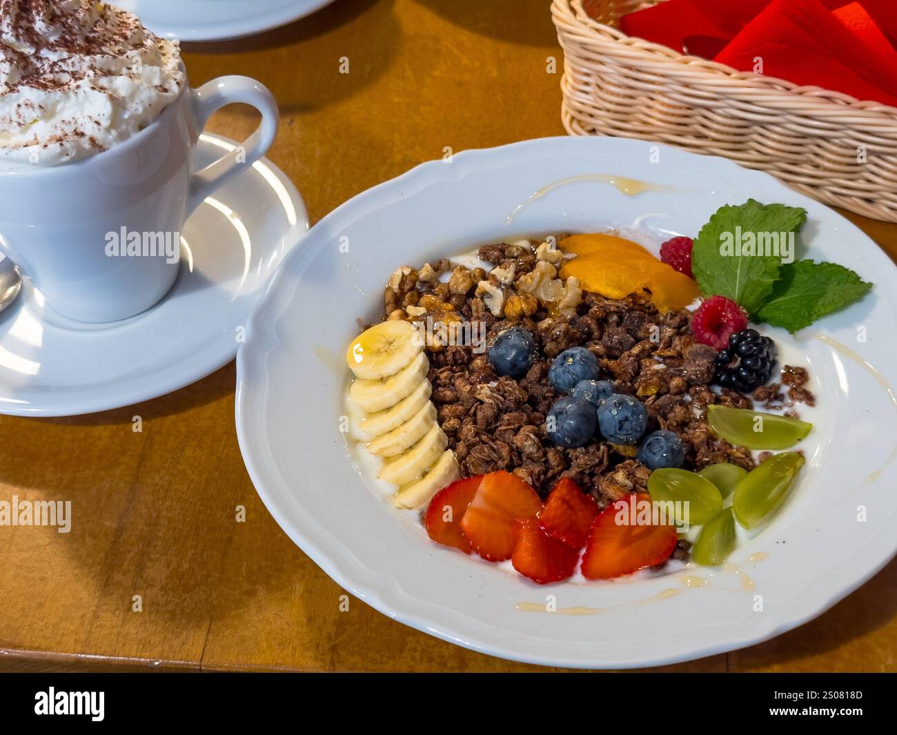 Verschiedene Früchte mit Körnern serviert in einem bole mit Joghurt. Stockfoto