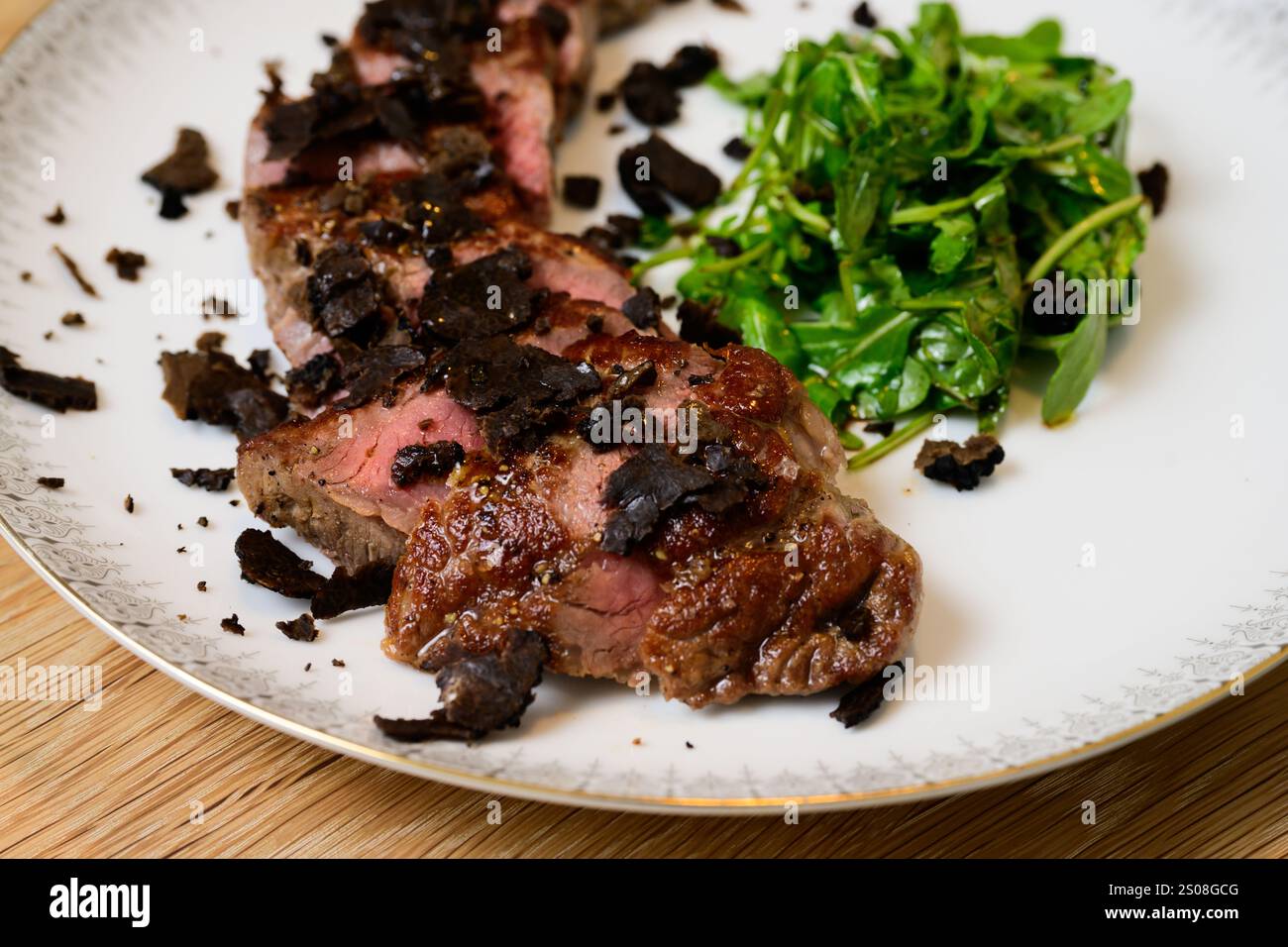 Tagliata di Manzo al Tartufo Rindersteak mit Trüffeln serviert mit grünem Rocket- oder Arugula-Salat Stockfoto