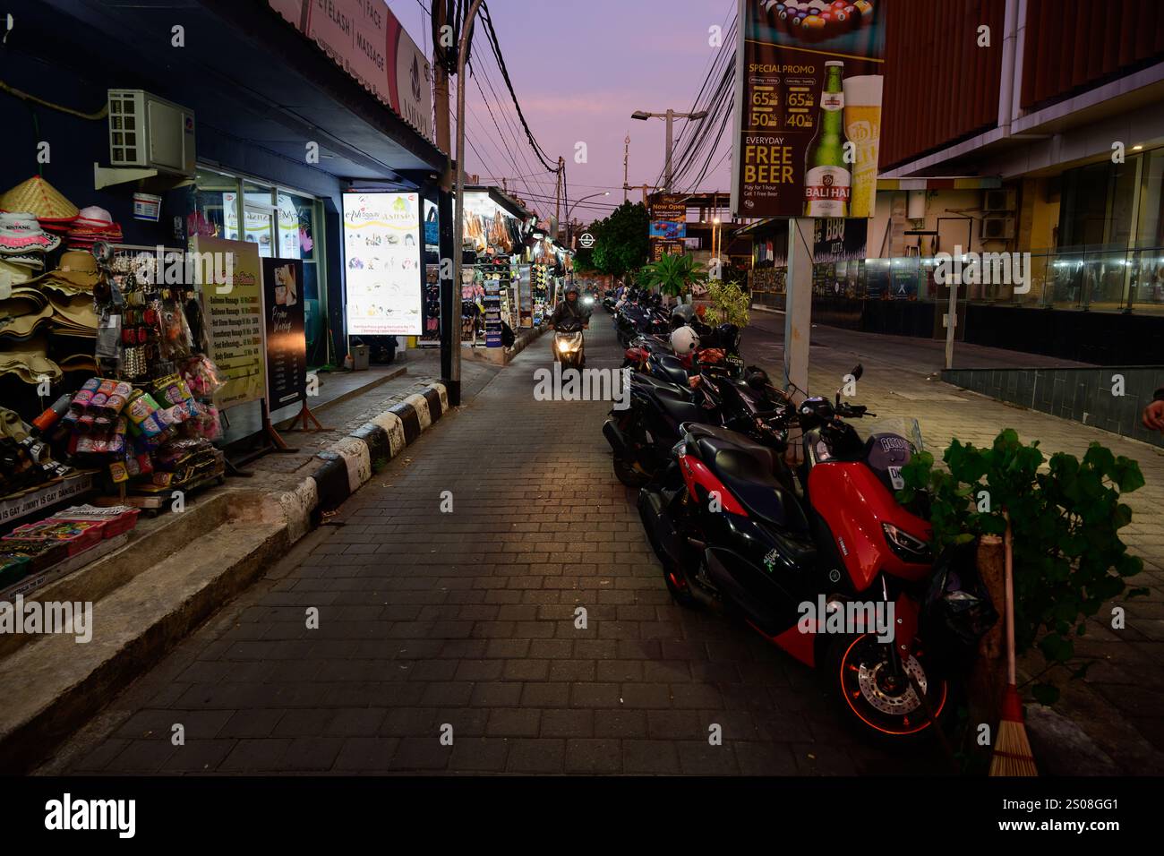 Kuta Beach, Bali, Indonesien - 7. November 2024: Straße mit Souvenirläden in der Abenddämmerung. Stockfoto