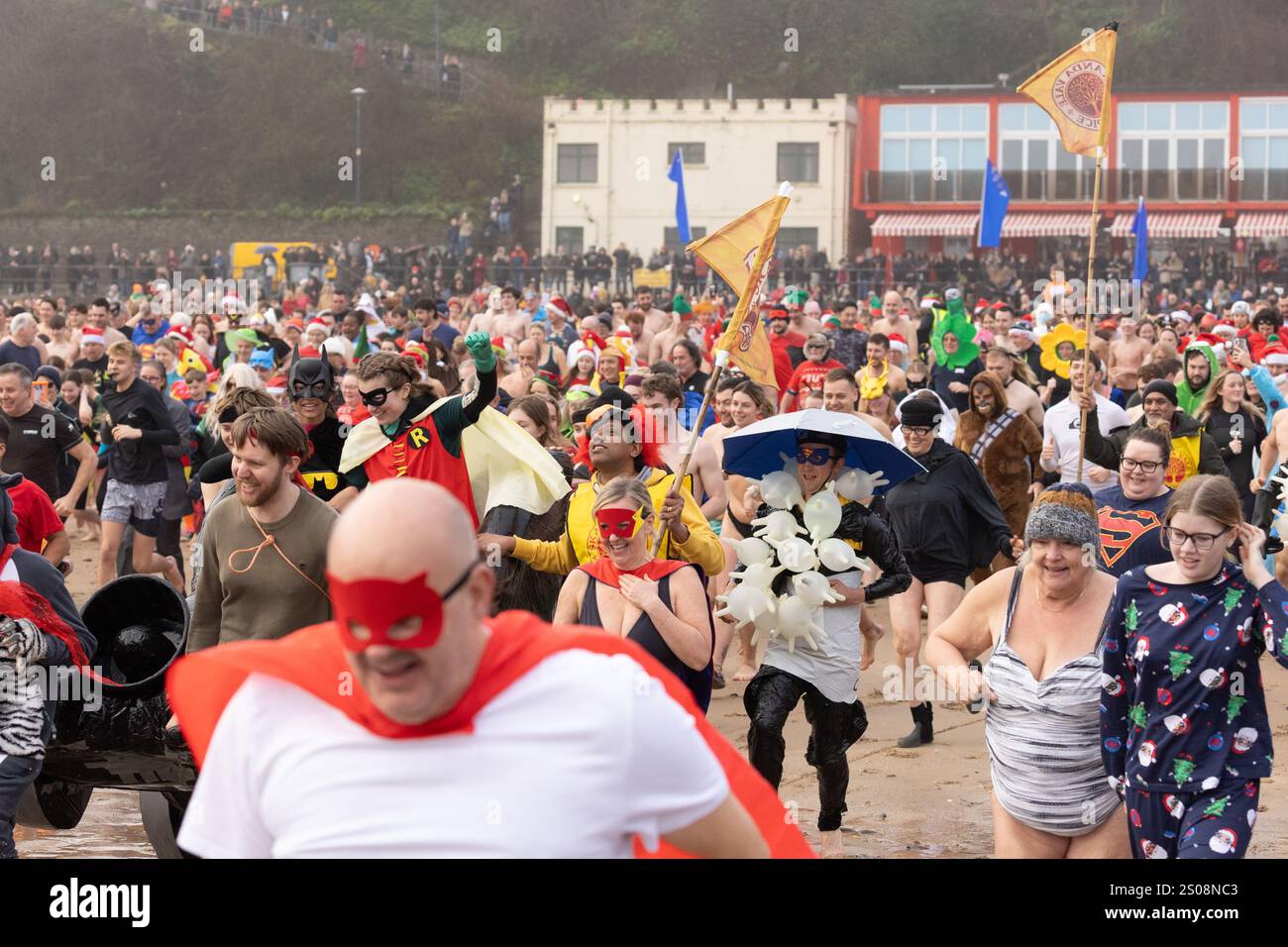 Tenby, Pembrokeshire, West Wales, Großbritannien. 26. Dezember 2024. Starker Nebel heute Morgen, als Hunderte zum jährlichen Weihnachtsfeiertag in Tenby schwimmen. Anrede: Andrew Bartlett/Alamy Live News Stockfoto