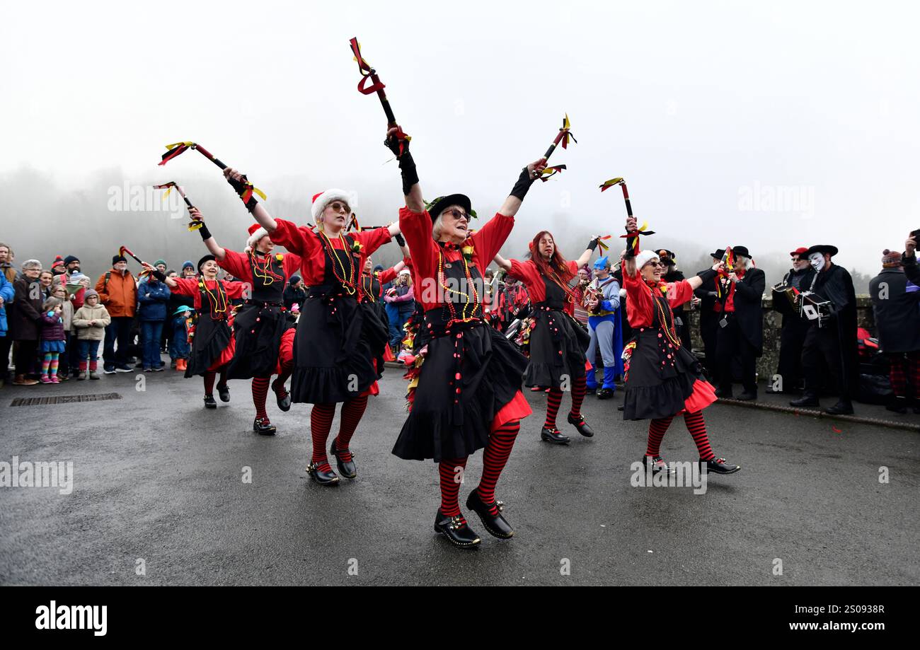 Ironbridge, Shropshire. Dezember 2024. Tänzer am zweiten Weihnachtsfeiertag erhellen einen trüben nebeligen Tag auf der berühmten Ironbridge. Die Ironmen und Severn Gilders Morris Dancers treten an jedem zweiten Weihnachtsfeiertag und Neujahrstag auf der Worlds First Ironbridge auf. Quelle: David Bagnall/Alamy Live News Stockfoto