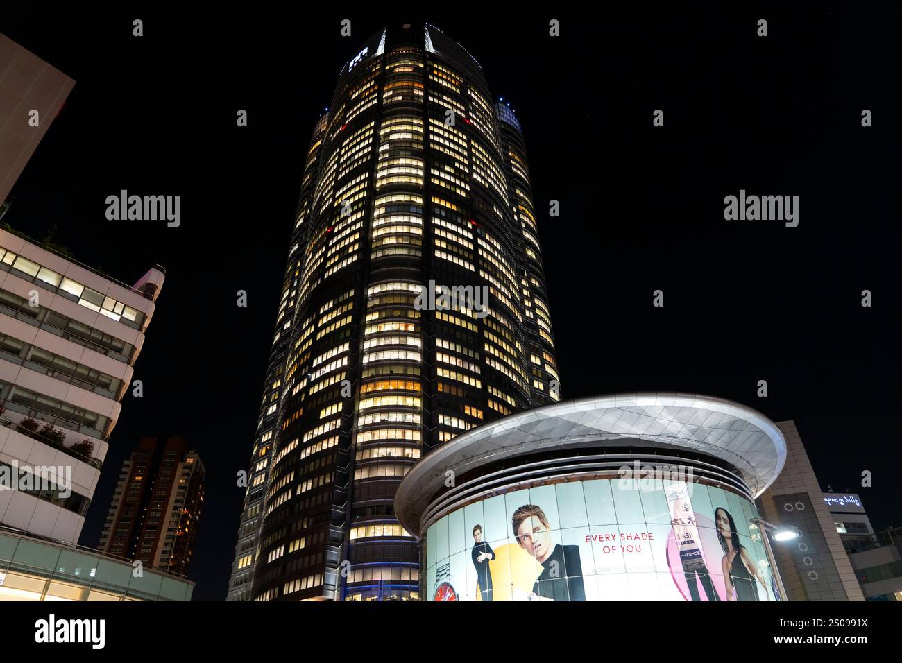 Das Metro hat Einkaufszentrum mit dem riesigen Roppongi Hill Mori Tower, der nachts im Roppongi Viertel von Tokio thront. Stockfoto