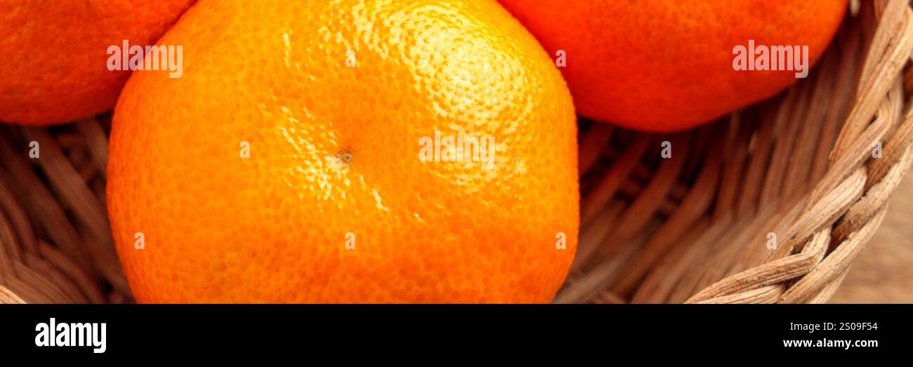 Leuchtend orange Mandarinen mit holpriger, strukturierter Schale in einem natürlichen Korb. Reife Bio-Zitrusfrüchte. Nahaufnahme. Draufsicht Stockfoto