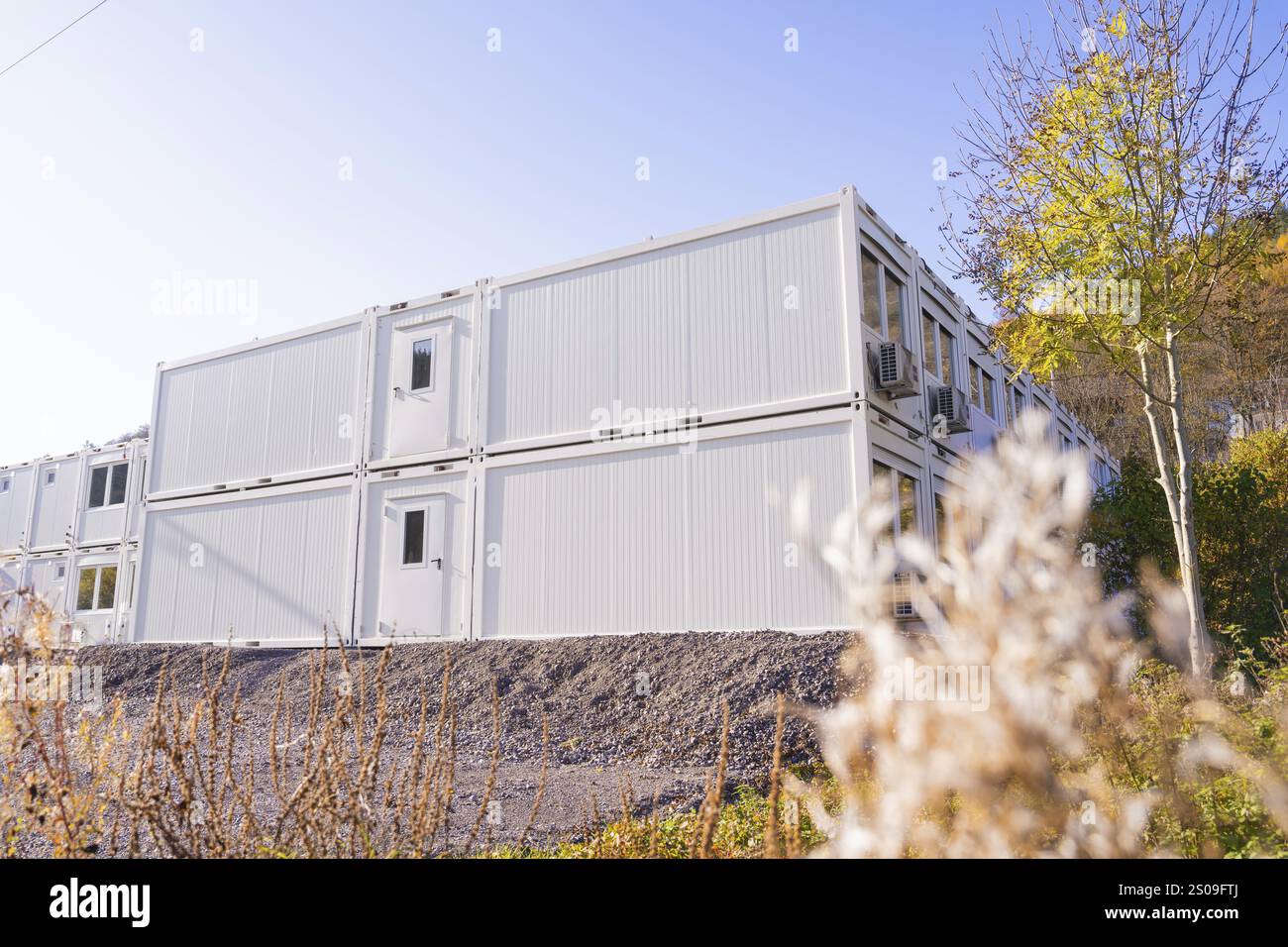Weiße Containergebäude mit Herbstbäumen in der Umgebung, ruhige Atmosphäre, Flüchtlingsunterkunft Beermiss, Calmbach, Schwarzwald, Deutschland, Eu Stockfoto