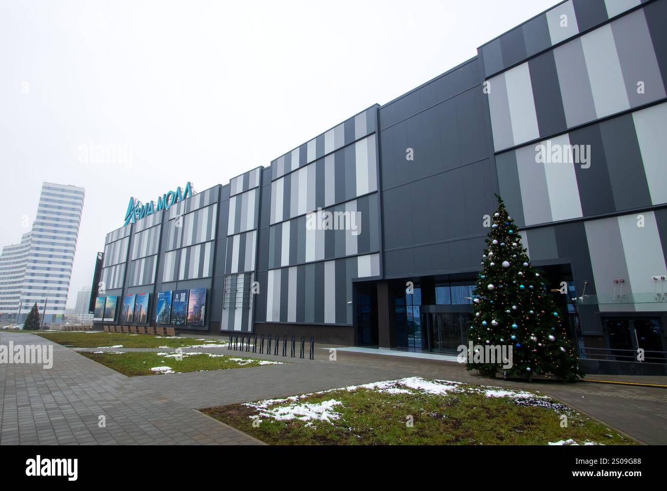 Weißrussland, Minsk - 26, 12, 2024: Es gibt ein großes und beeindruckendes Gebäude mit einem wunderschön dekorierten Weihnachtsbaum, der rechts oben steht Stockfoto