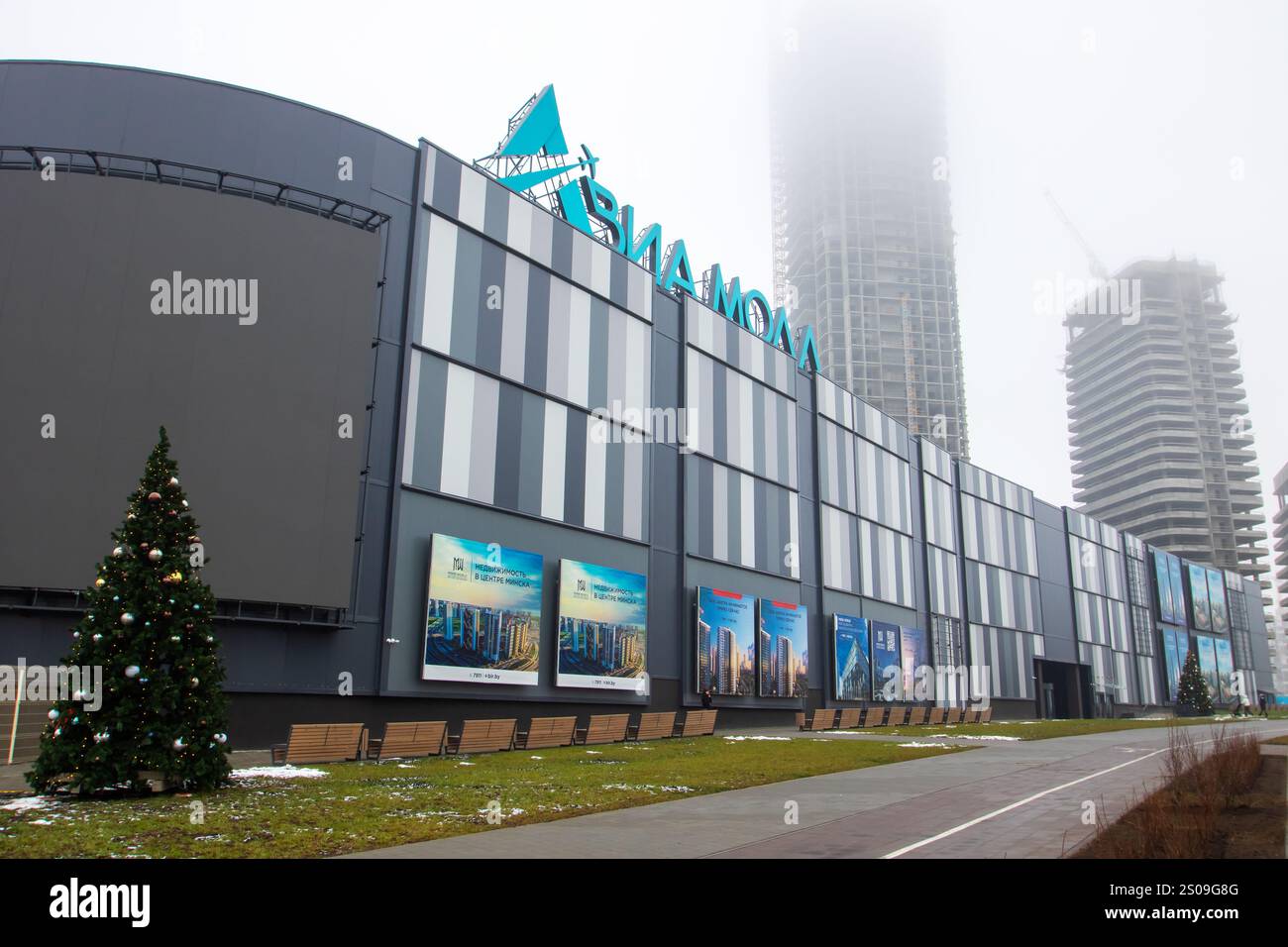 Weißrussland, Minsk - 26, 12, 2024: Es gibt ein großes und beeindruckendes Gebäude mit einem wunderschön dekorierten Weihnachtsbaum, der rechts oben steht Stockfoto