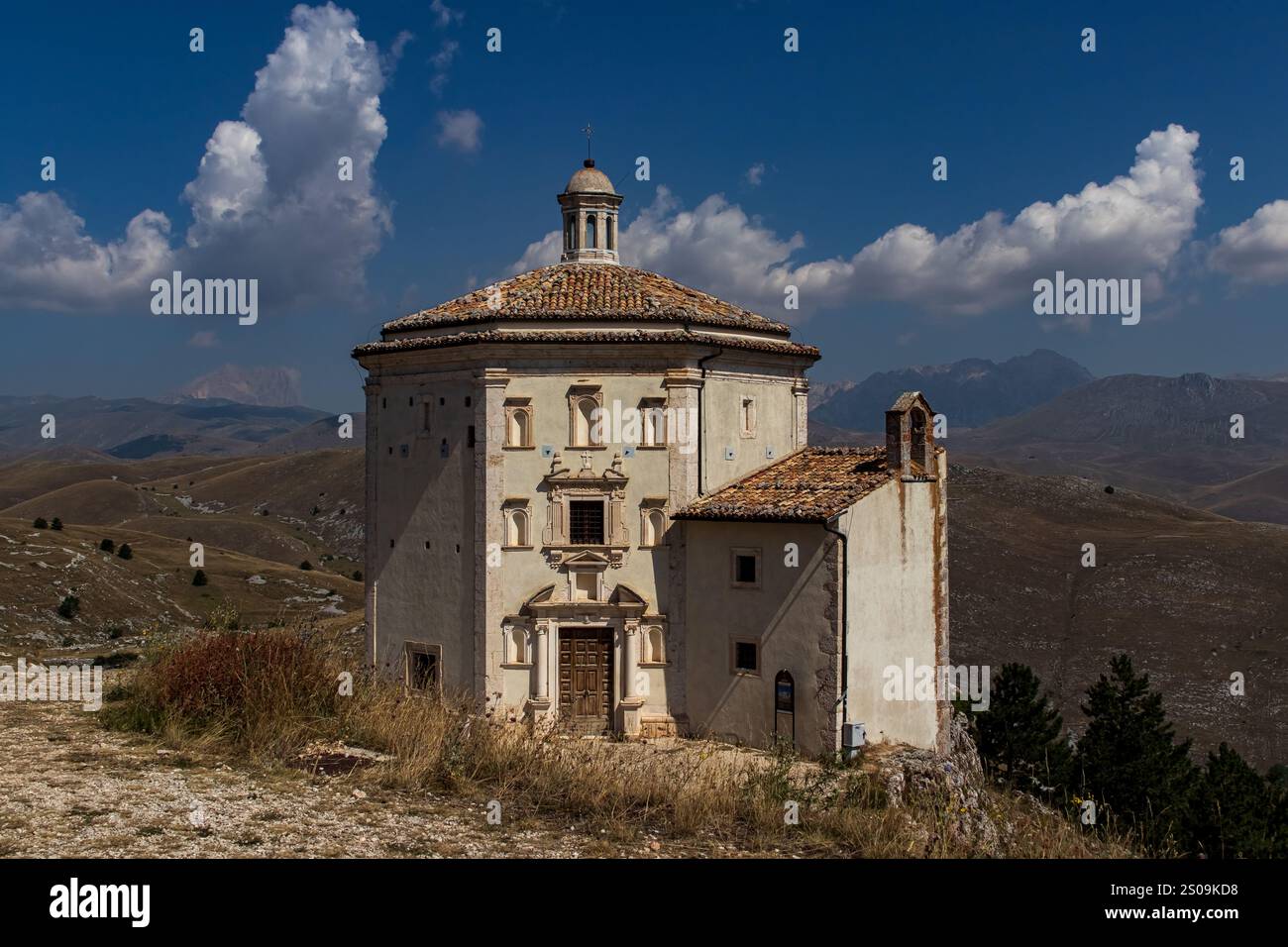Farbenfrohe Landschaft mit sanften Hügeln unter einem pulsierenden Himmel, mit fernen Bergen, die eine ruhige und majestätische Naturlandschaft schaffen Stockfoto