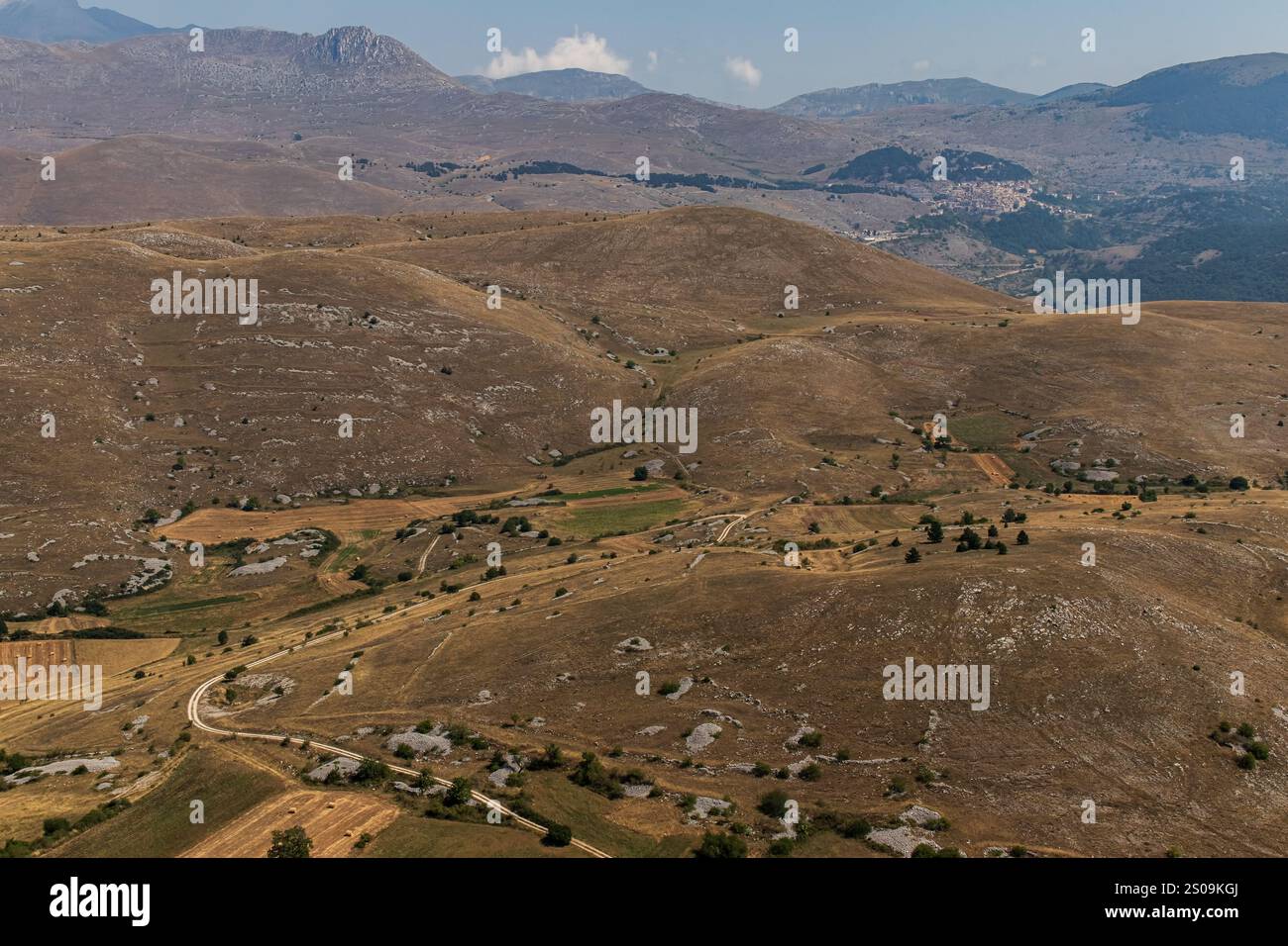 Farbenfrohe Landschaft mit sanften Hügeln unter einem pulsierenden Himmel, mit fernen Bergen, die eine ruhige und majestätische Naturlandschaft schaffen Stockfoto