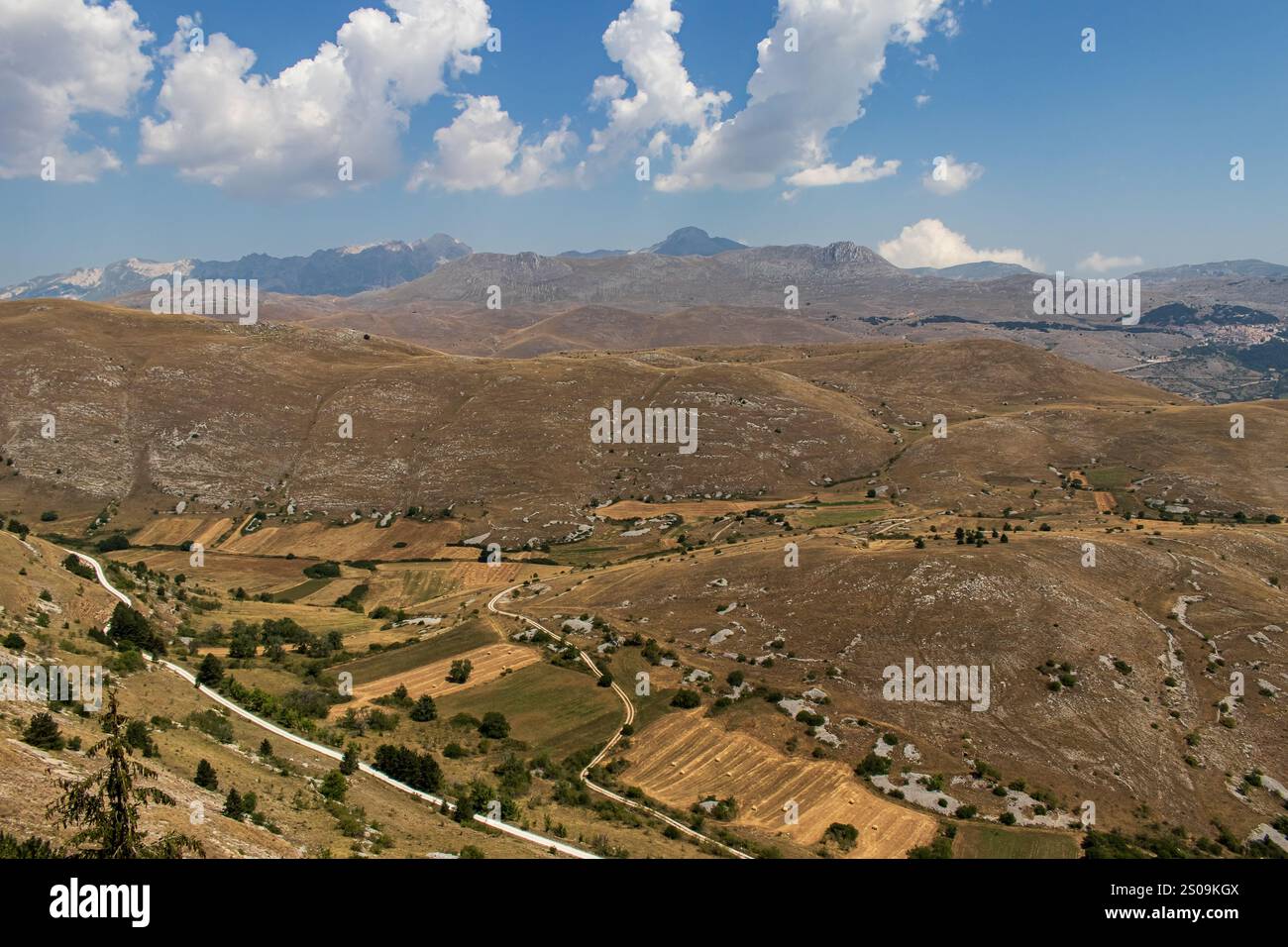 Farbenfrohe Landschaft mit sanften Hügeln unter einem pulsierenden Himmel, mit fernen Bergen, die eine ruhige und majestätische Naturlandschaft schaffen Stockfoto