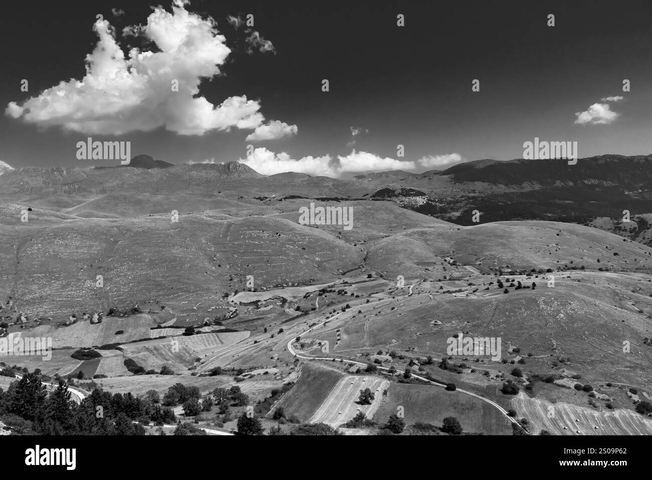 Schwarz-weiße Landschaft mit dramatischem Himmel und kargen Hügeln, die die zeitlose Schönheit und das Wesen der Natur einfangen Stockfoto