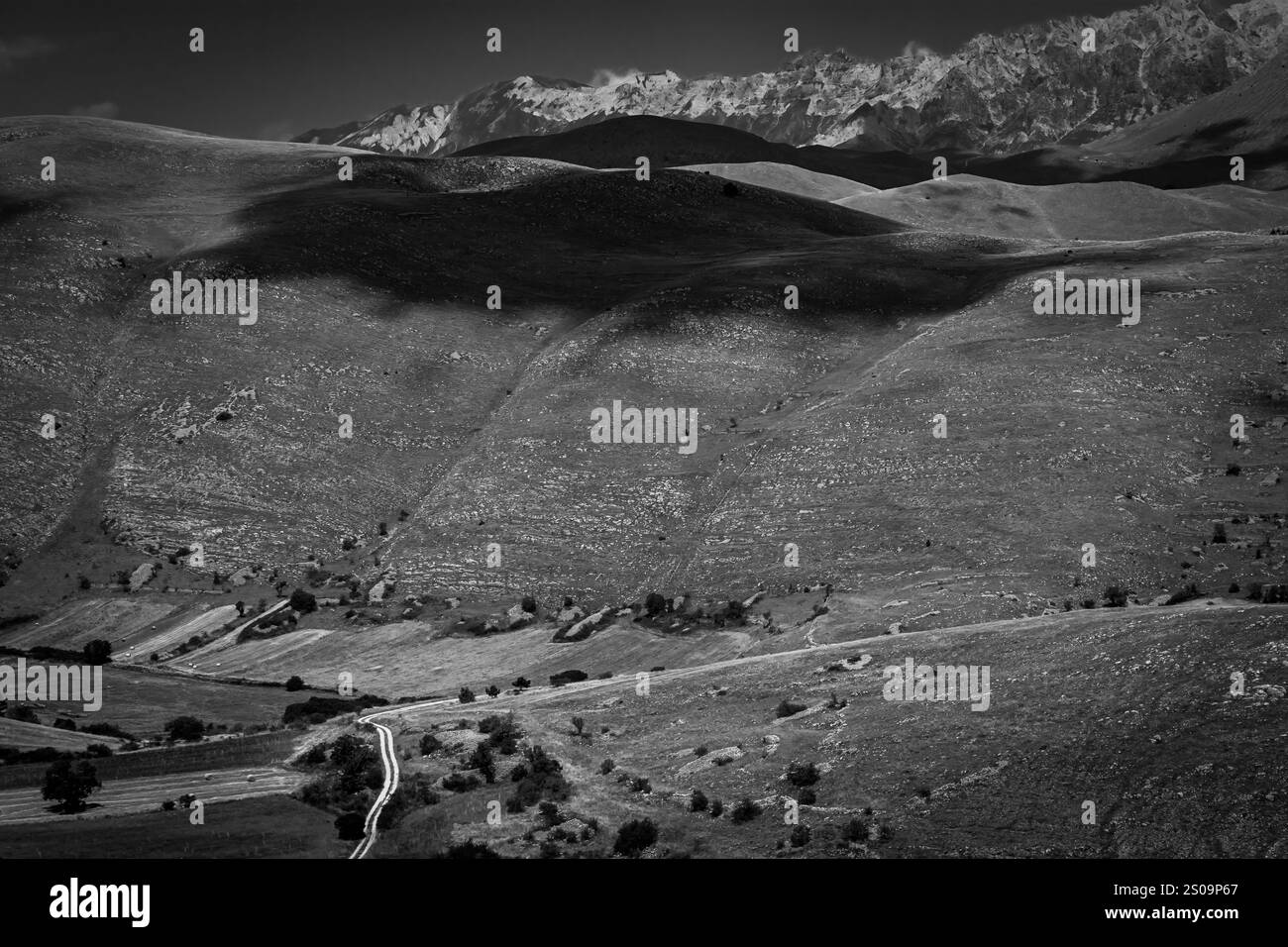 Schwarz-weiße Landschaft mit dramatischem Himmel und kargen Hügeln, die die zeitlose Schönheit und das Wesen der Natur einfangen Stockfoto