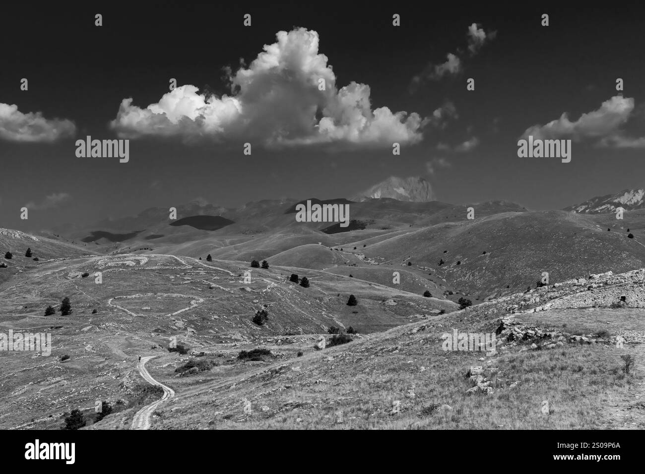Schwarz-weiße Landschaft mit dramatischem Himmel und kargen Hügeln, die die zeitlose Schönheit und das Wesen der Natur einfangen Stockfoto
