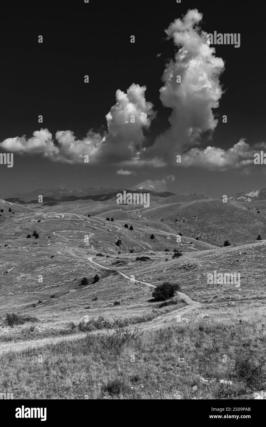 Schwarz-weiße Landschaft mit dramatischem Himmel und kargen Hügeln, die die zeitlose Schönheit und das Wesen der Natur einfangen Stockfoto