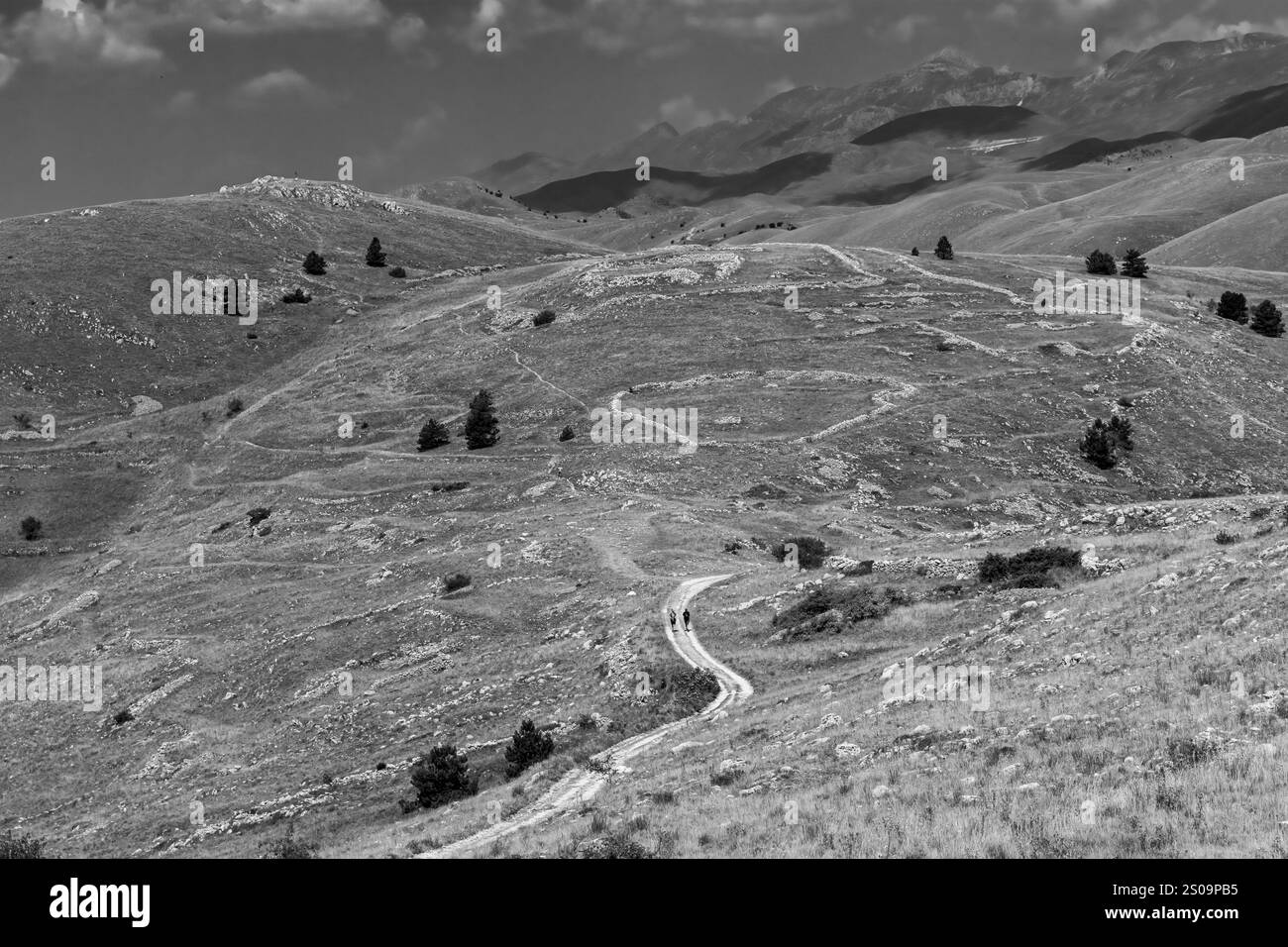 Schwarz-weiße Landschaft mit dramatischem Himmel und kargen Hügeln, die die zeitlose Schönheit und das Wesen der Natur einfangen Stockfoto