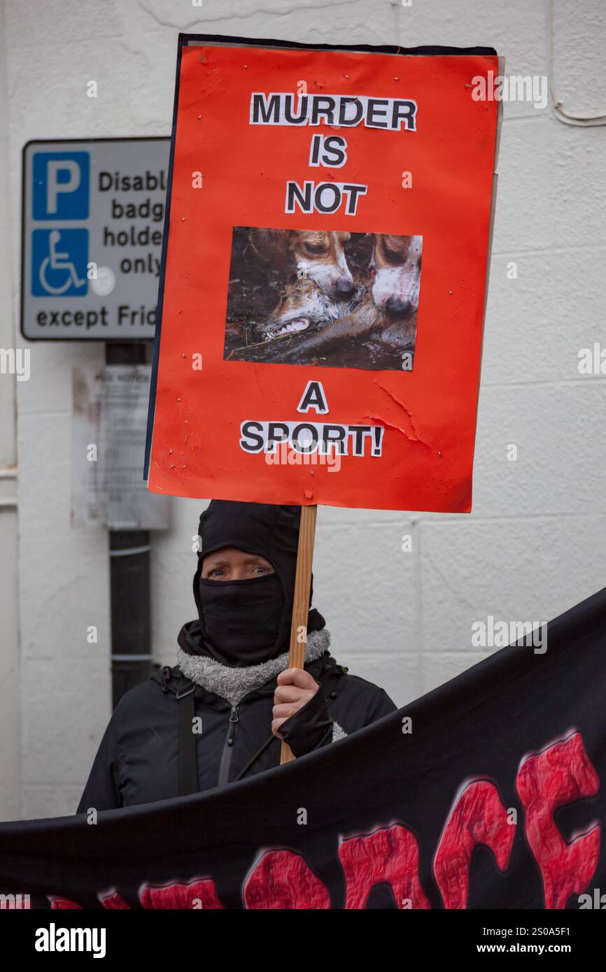 Leominster, Großbritannien. Dezember 2024. Ein Anti-Fuchs-Protestler hält ein Plakat während der jährlichen Boxing Day Hunt. Eine kleine Gruppe, die die Herefordshire Hunt SABs repräsentierte, versammelte sich, um gegen den Sport der Fox-Jagd zu protestieren. Mitglieder der Hereford and Clifton Hunt versammelten sich am Corn Square zur traditionellen jährlichen Jagd am Boxing Day, zur Freude der Einheimischen, die sich versammelt hatten, um sie zu begrüßen. Quelle: SOPA Images Limited/Alamy Live News Stockfoto