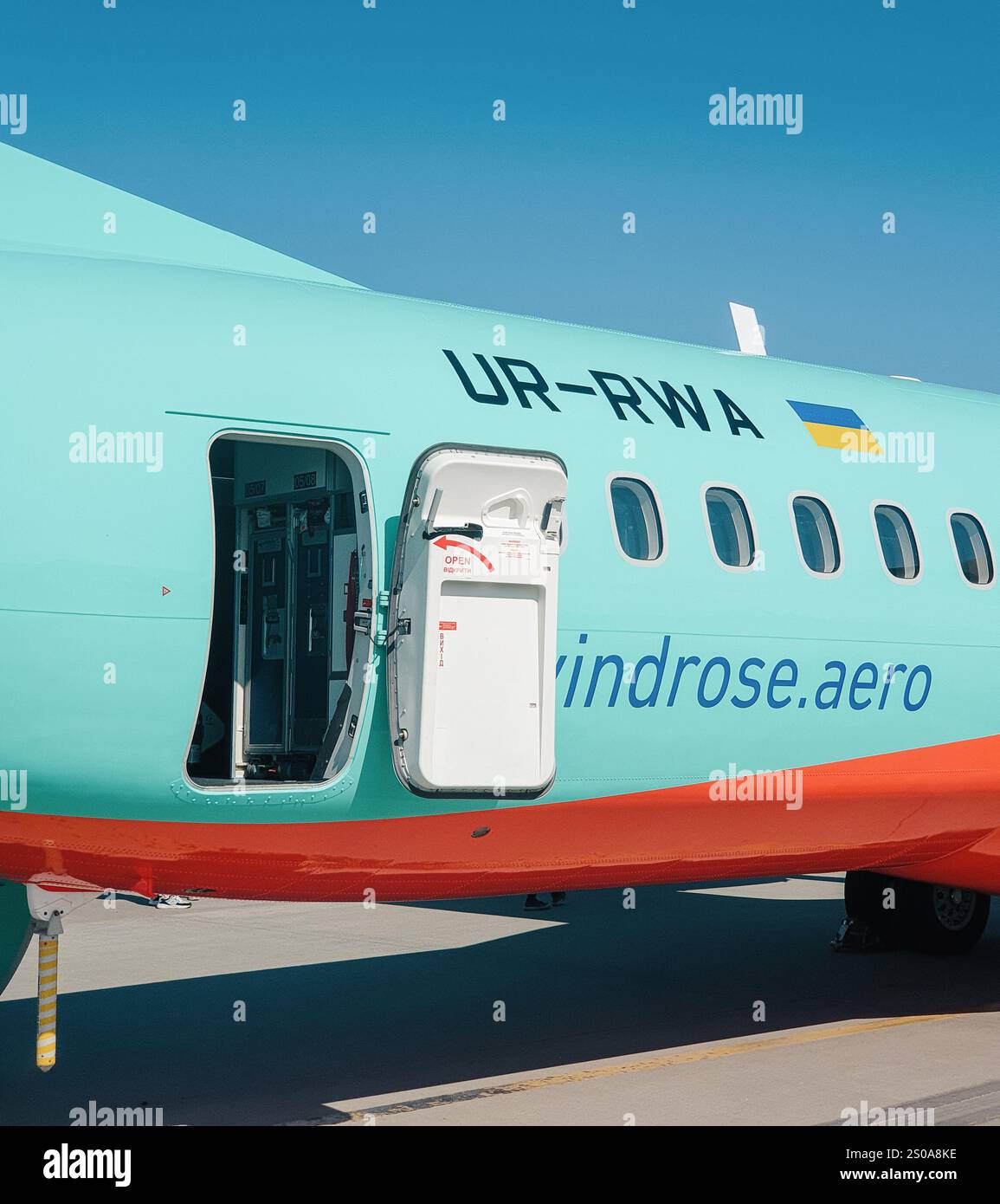 Hinterer Ausgang des Passagierflugzeugs von Windrose UR-RWA. Heckteil des türkisfarbenen Flugzeugs ATR 72 während der Flugvorbereitungen. Stockfoto