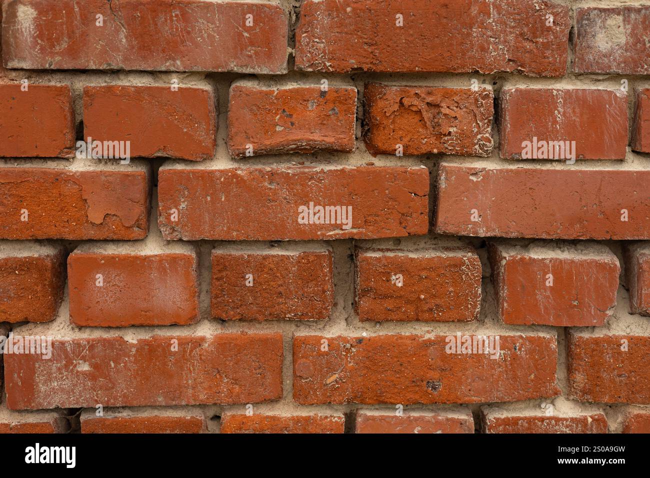 Nahtstruktur der alten roten Ziegelwand mit verwitterter Oberfläche und sichtbaren Mörtelnähten, die industriellen Charme und zeitlose architektonische Details zeigen Stockfoto