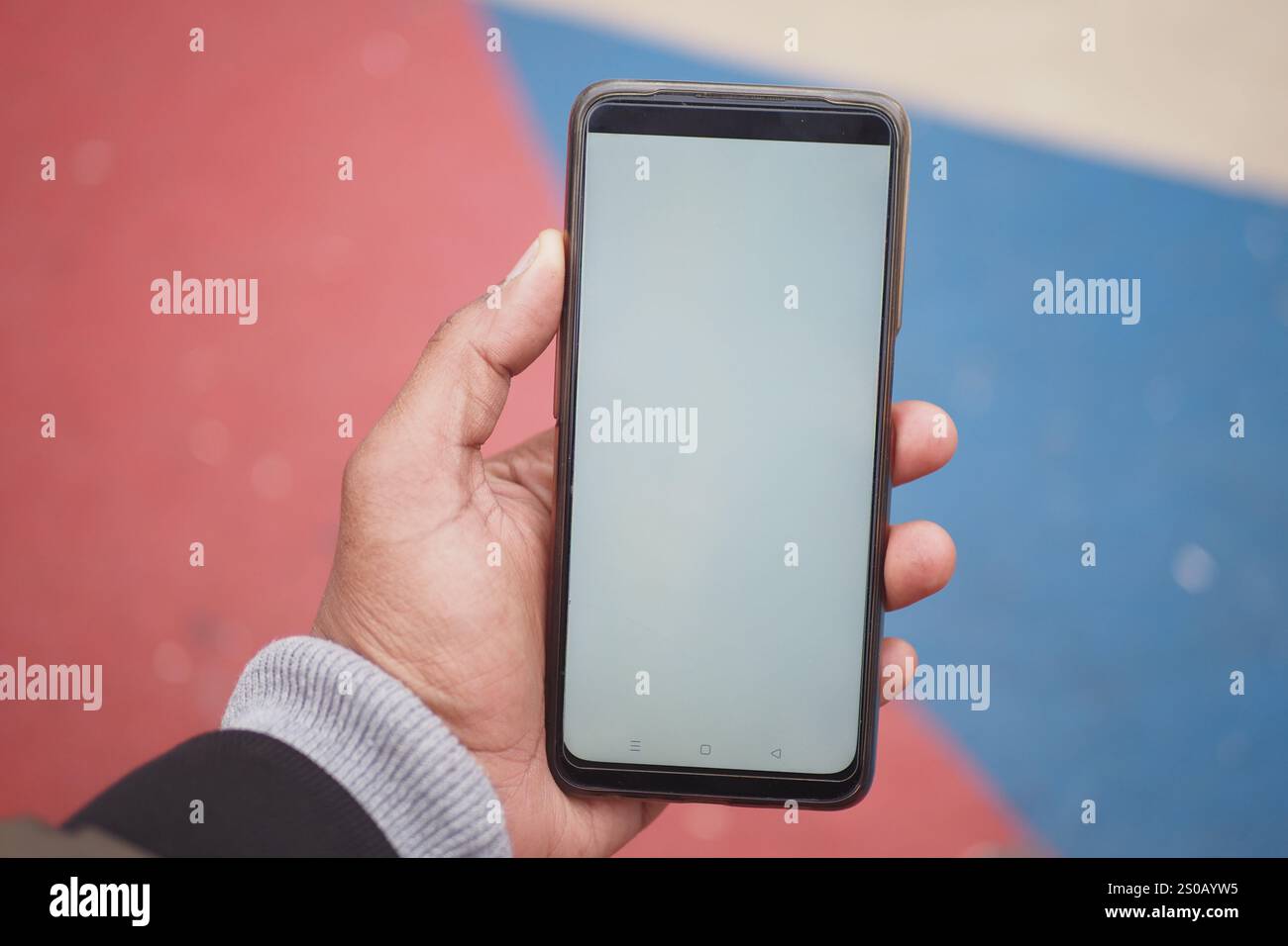 Handheld-Smartphone mit leerem Bildschirm in farbenfroher Einstellung Stockfoto