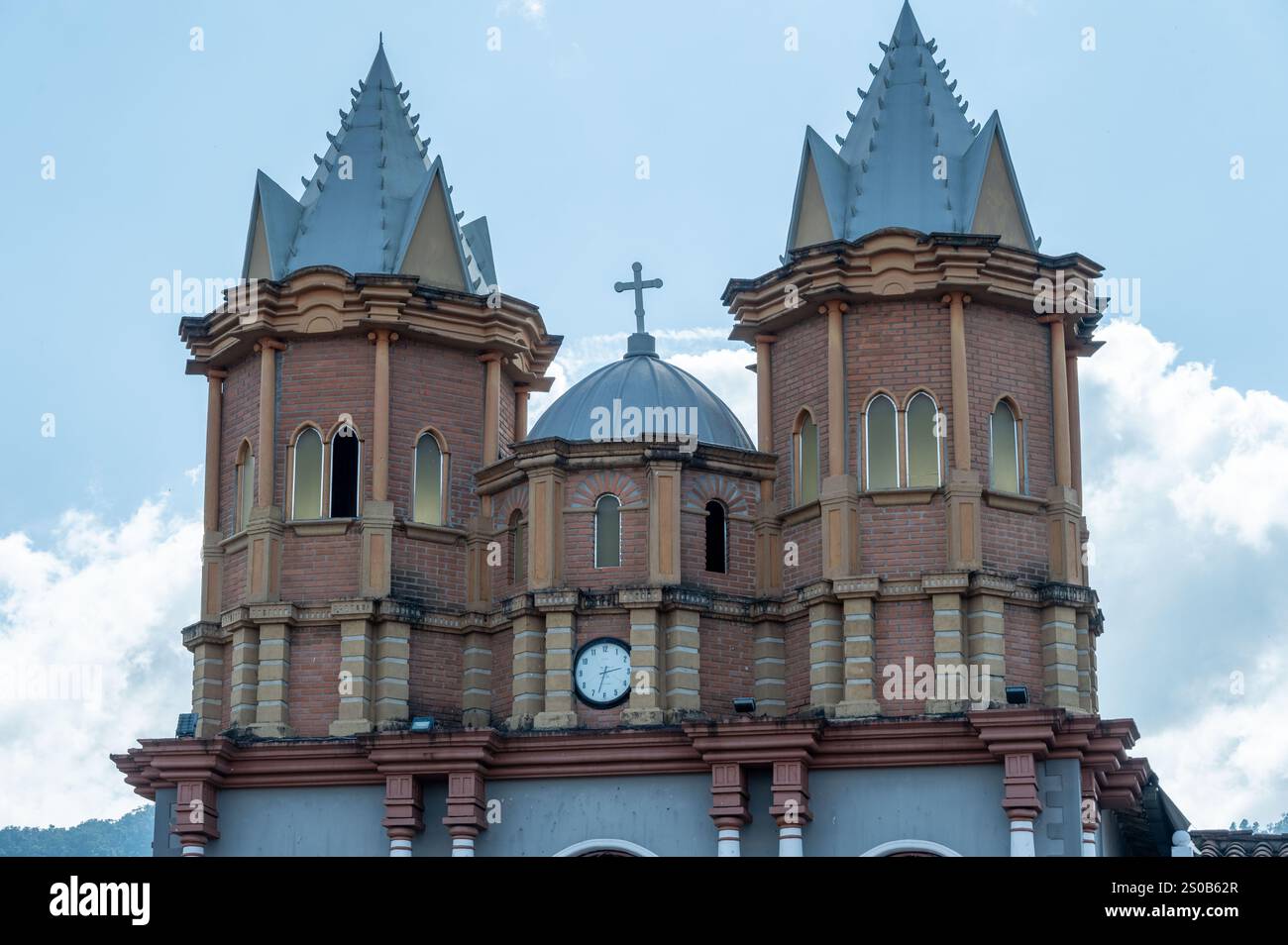 Architektonisches Wunder. Das komplizierte Design einer Kirche und die hohen Türme vor einem klaren Himmel. Stockfoto