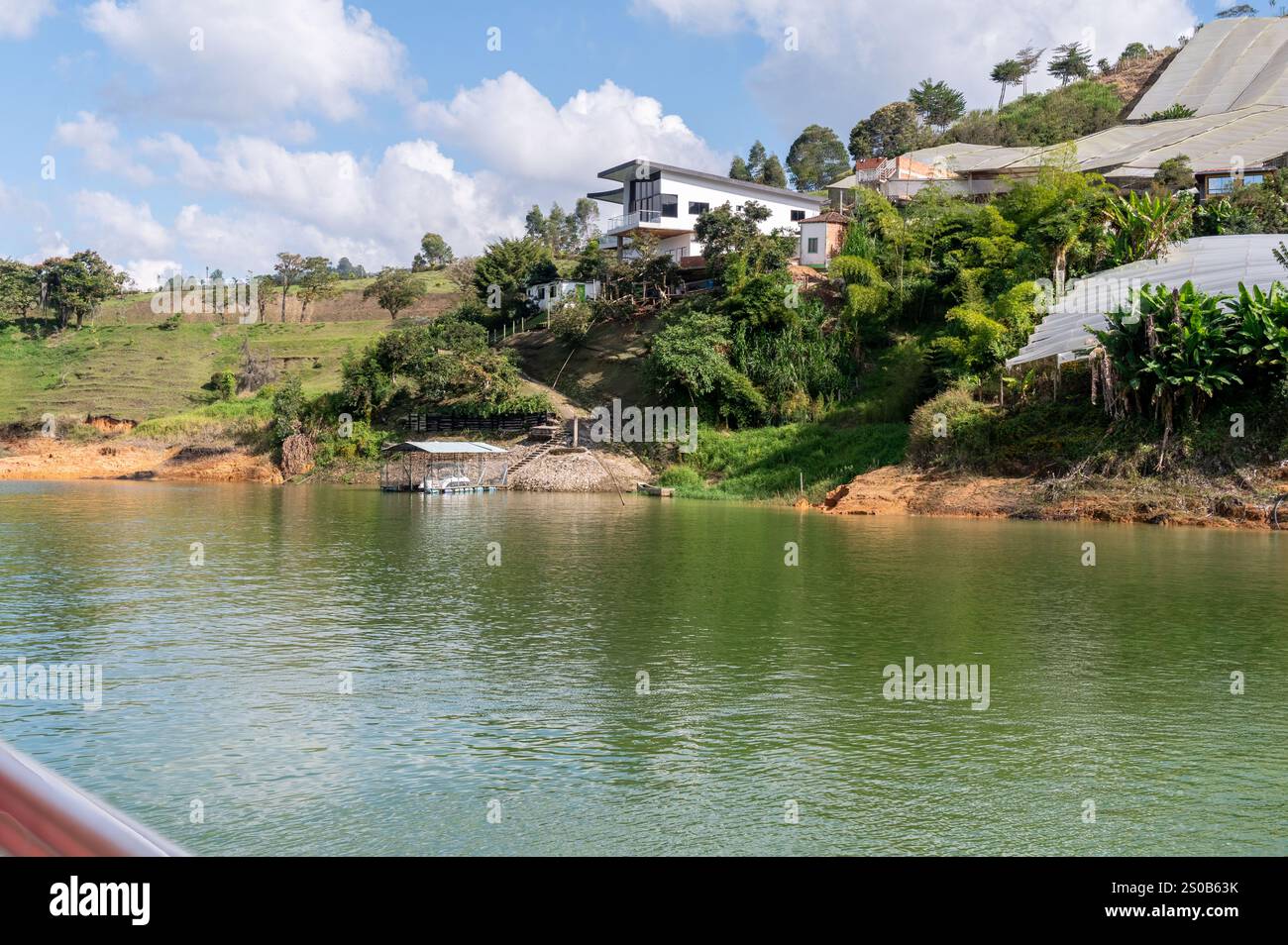 Ruhe am See. Moderne Architektur eingebettet in üppiges Grün und ruhiges Wasser. Ein friedlicher Zufluchtsort. Stockfoto