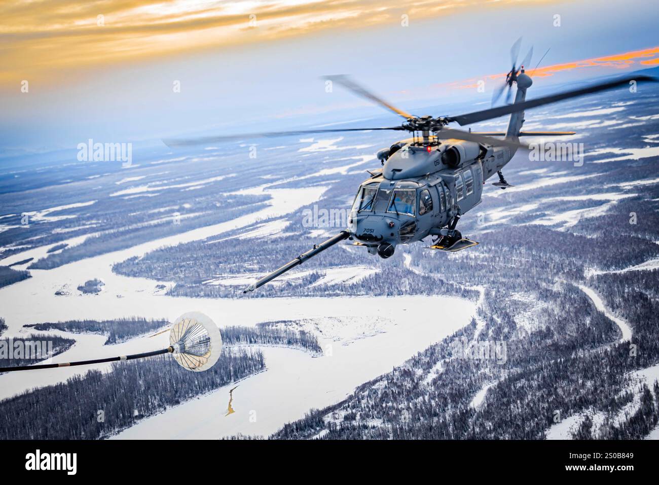 17. Dezember 2024 - Joint Base Elmendorf-Richardson, Alaska, USA - Ein U.S. Air Force HH-60G Pave Hawk, der der 210th Rescue Squadron, 176th Wing, Alaska Air National Guard zugewiesen ist, führt einen Helikopter-Luft-Luft-Betankung mit einem U.S. Marine Corps KC-130J durch, das der Marine Aerial Refueler Transport Squadron (VMGR) 153, Marine Aircraft Group 24, 1st Marine Aircraft Wing während eines Trainings in Richardson, DFT, 17. Dezember 2024. Das DFT stellte VMGR-153-Piloten und -Besatzungsmitgliedern ein Training auf Einheitenebene zur Verfügung, das die Kampfbereitschaft der Geschwader verbesserte und gleichzeitig die Co-Mitarbeiter unterstützte Stockfoto