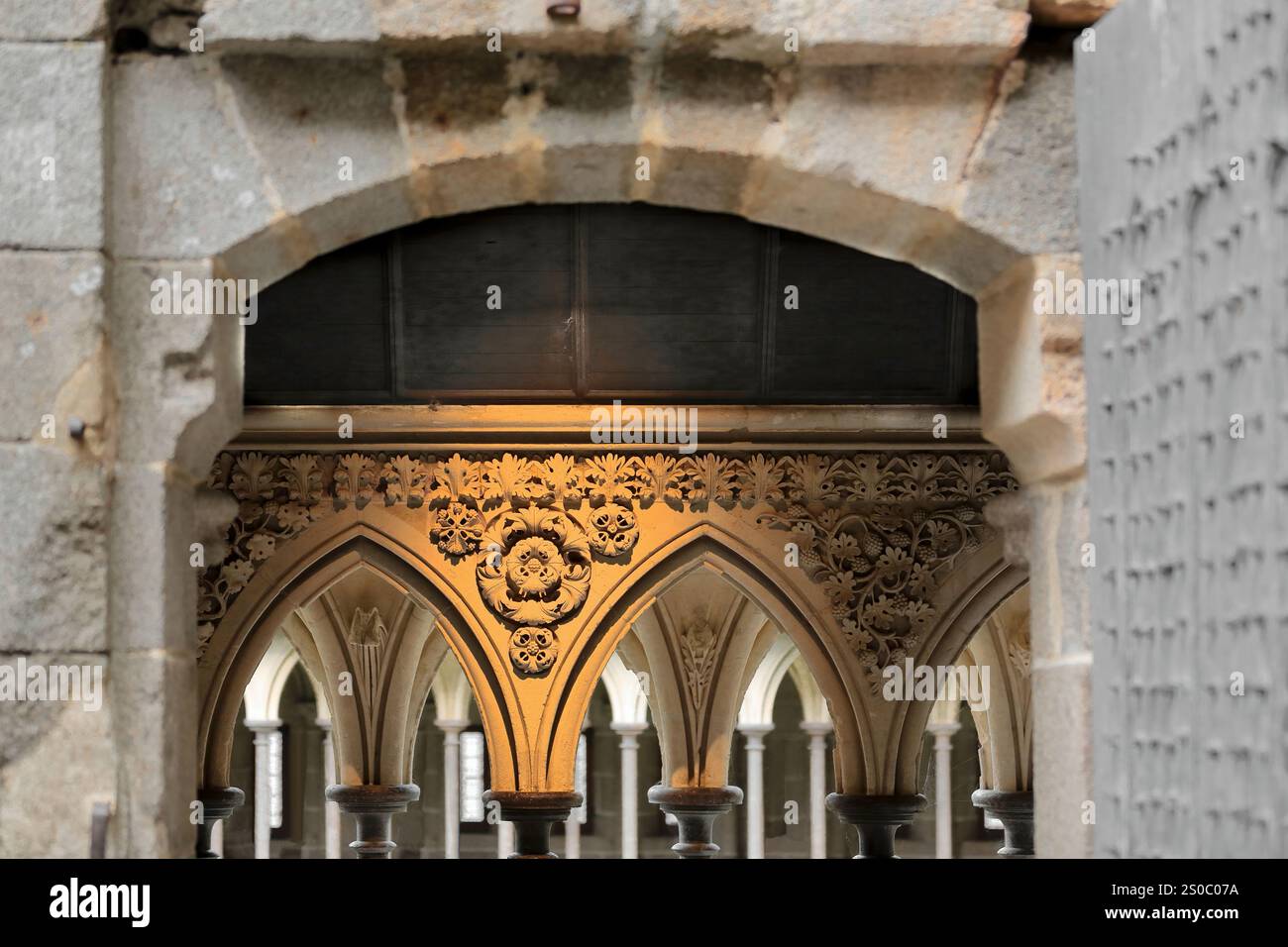 121 in der Südgalerie des Klosters wurden Spandrels über spitzen Bögen auf Säulen geformt, die in einem versetzt angeordneten Muster angeordnet sind, Le Mont-Saint-Michel. Normandie-Frankreich Stockfoto