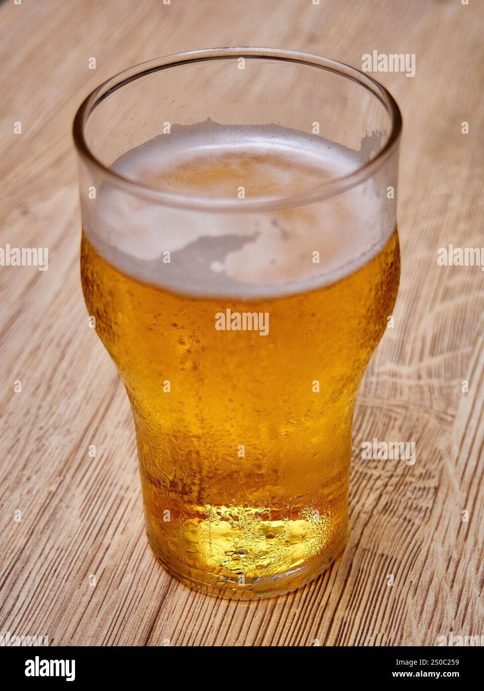 Ein Glas Bier auf hölzernem Hintergrund. Bier im Glas. Stockfoto