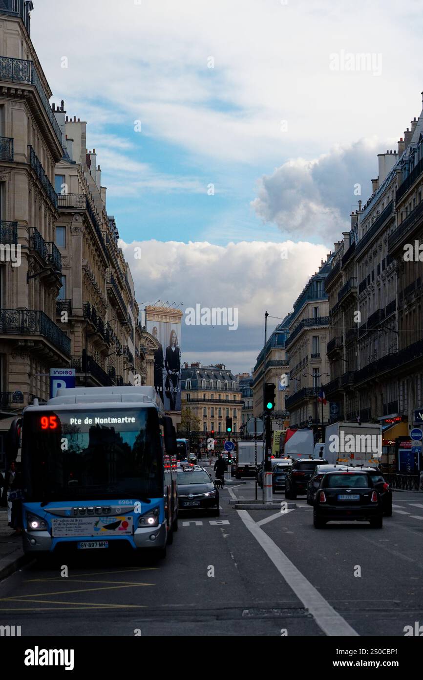 Blick auf die Stadt in Paris mit einem Bus und Autos unter bewölktem Himmel, der die urbane Landschaft und Architektur in der geschäftigen Atmosphäre zeigt Stockfoto