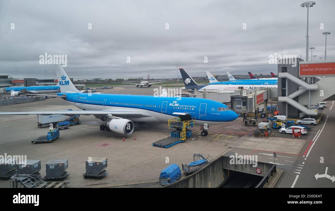 Internationaler Flughafen Schiphol ein KLM Royal Dutch Airlines Flugzeug, das am Gate geparkt ist und die Bodenbesatzung effizient arbeitet. - Smartphone-aufgenommenes Stockfoto