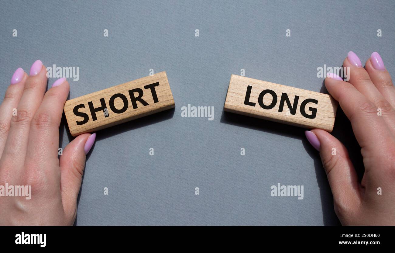 Symbol kurz vs lang. Konzeptwort kurz vs lang auf Holzblöcken. Geschäftsmann Hand. Schöner grauer Hintergrund. Business und kurz- vs Langkonzept. Co Stockfoto