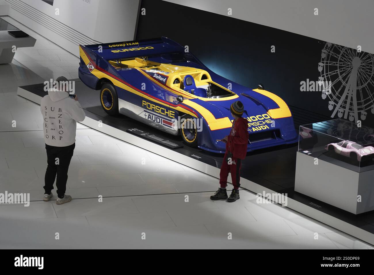 Menschen fotografieren einen gelb-blauen Porsche-Rennwagen in einer Ausstellung, Ausstellung, Neues Porschemuseum 2009, Stuttgart, Baden-Württemberg, Germa Stockfoto