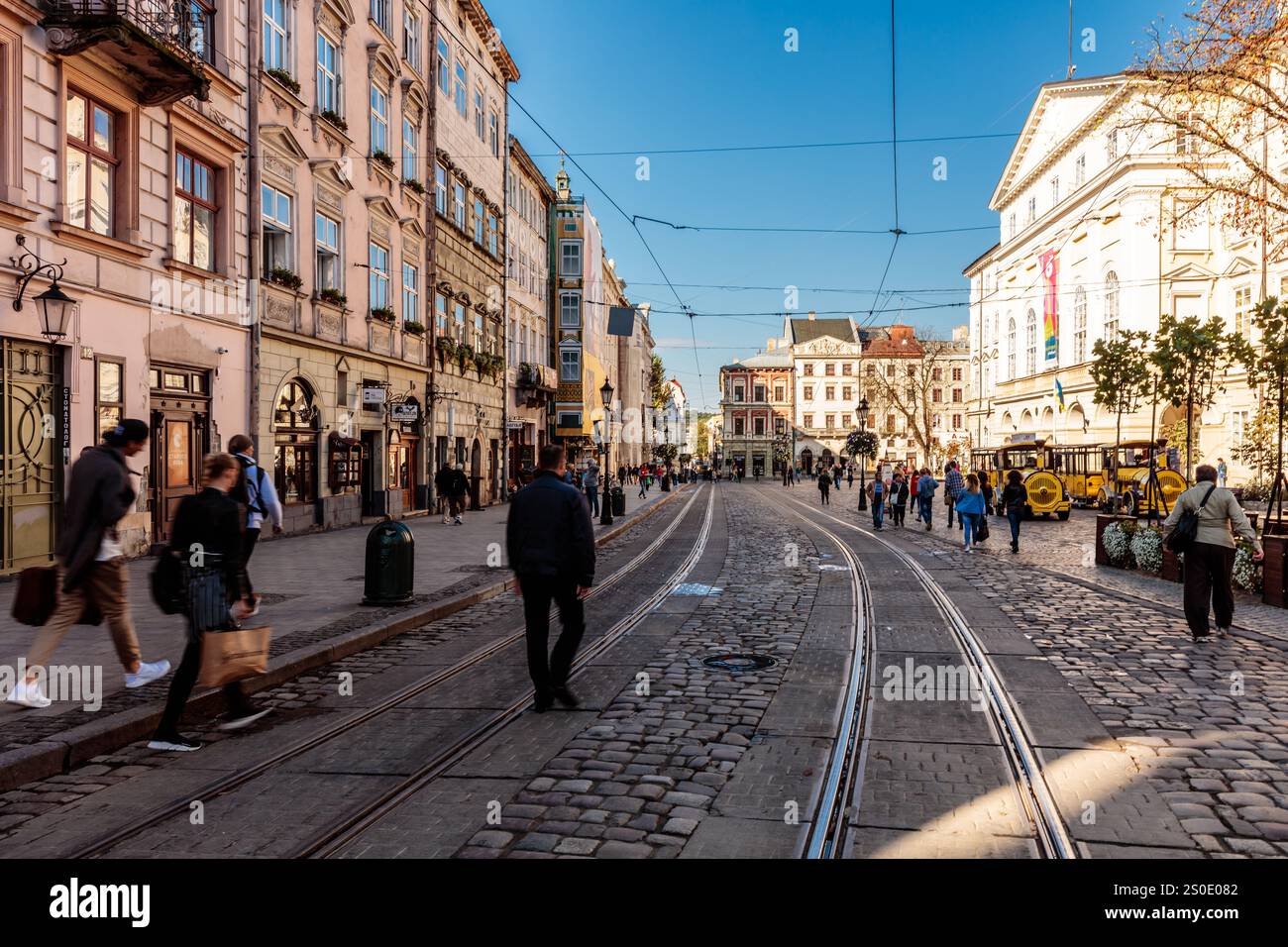 Eine belebte Straße in der Stadt mit Leuten, die zu Fuß laufen, und einem gelben Taxi. Die Szene ist lebhaft und geschäftig Stockfoto