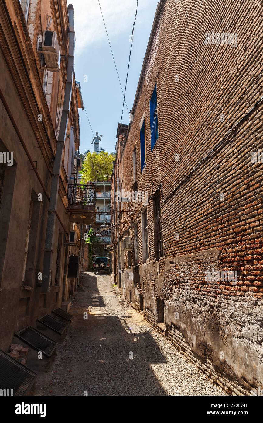 Altes Tiflis, Blick auf die enge Straße mit Kartlis Deda-Denkmal im Hintergrund, vertikales Foto Stockfoto