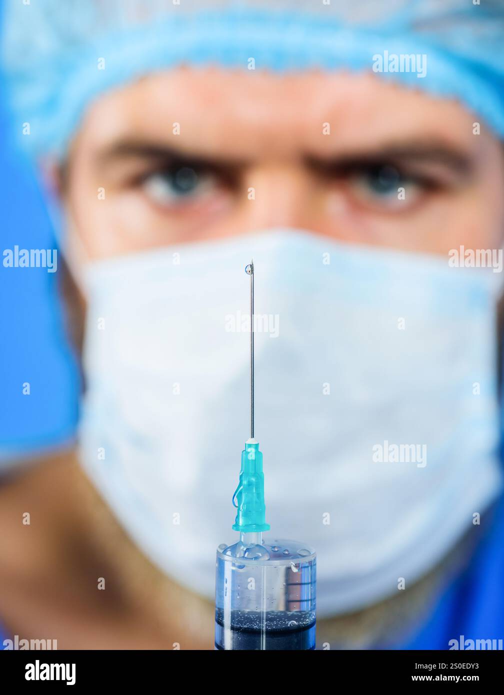 Männlicher Arzt in chirurgischer Maske, der Spritze mit Nadel für die Injektion vorbereitet. Impfungen für Menschen. Arzt in Uniform hält Spritze mit Impfstoff. Dok Stockfoto