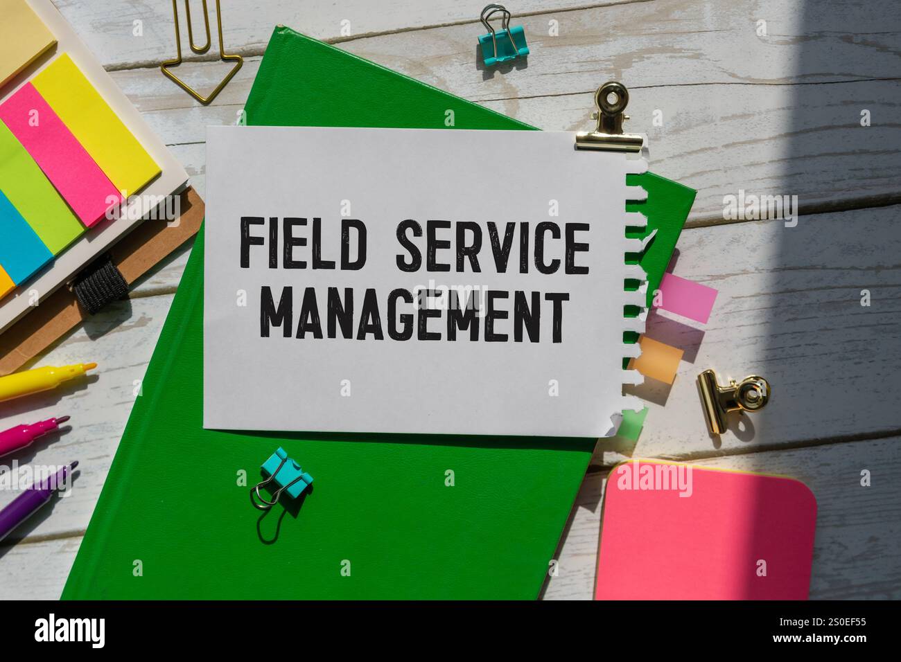 Auf hellblauem Hintergrund helle Holzblöcke und Würfel mit dem Text FSM Field Service Management. Stockfoto